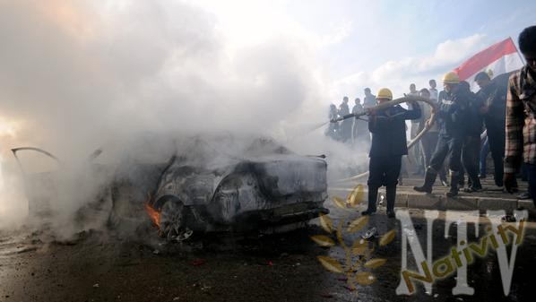 Egyptian firefighters douse a burning car set on fire during a demonstration calling for a "No" vote in a referendum on a new constitution in the coastal city of Alexandria on December 14, 2012. Stone-throwing clashes broke out between Islamists and opposition supporters in Alexandria on the eve of the highly charged referendum, witnesses said. There was no immediate word on any casualties but witnesses told AFP street violence was continuing in Egypt's second-biggest city despite police efforts to restore order. AFP PHOTO/STR (Photo credit should read STR/AFP/Getty Images)