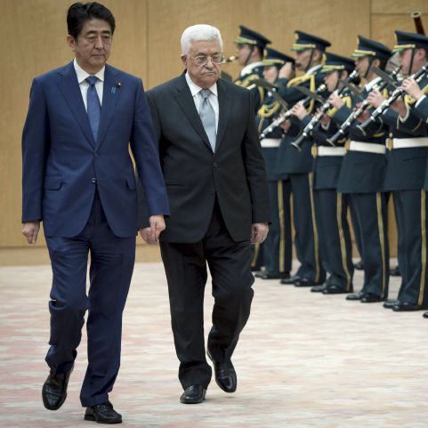 Japan's Prime Minister Shinzo Abe (L) and Palestinian President Mahmoud Abbas review the honour guard before talks at Abe's official residence in Tokyo, Japan, February 15, 2016. REUTERS/Nicolas Datiche/Pool