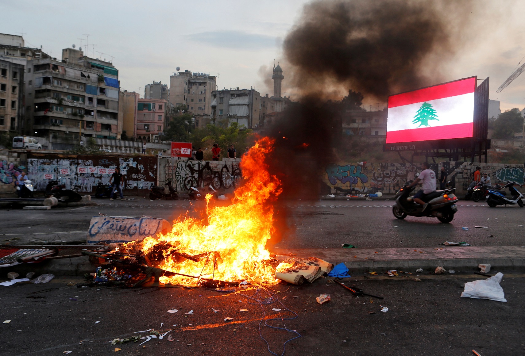 A man drives near fire set by the demonstrators in Beirut, Lebanon, October 25, 2019. REUTERS/Mohamed Azakir