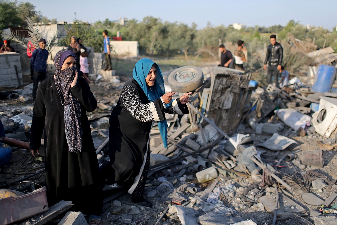 Palestinian women react as they inspect a house destroyed in an Israeli air strike in the southern Gaza Strip November 14, 2019. REUTERS/Ibraheem Abu Mustafa