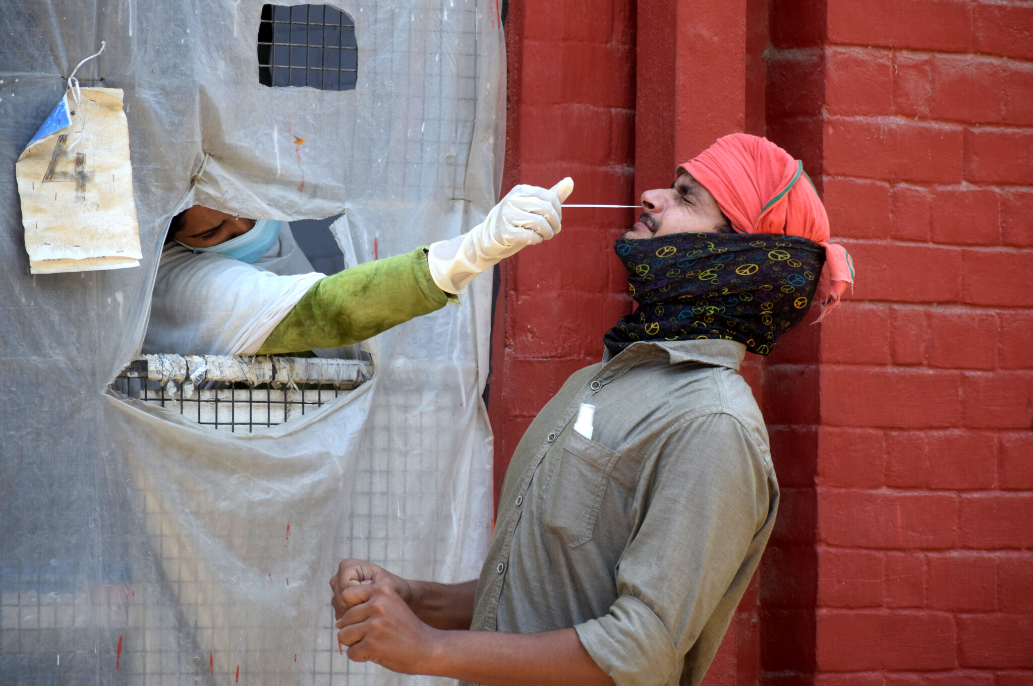 (210516) -- PRAYAGRAJ, May 16, 2021 (Xinhua) -- A health worker takes a nasal swab sample from a man to test with Rapid Antigen Test (RAT) for the COVID-19 in Prayagraj, India's northern state of Uttar Pradesh, May 16, 2021. The number of confirmed COVID-19 cases in India on Sunday morning rose to 24,684,007 and the related death toll across the country stands at 270,284, India's federal health ministry said. During the past 24 hours, 311,170 new cases and 4,077 related deaths were reported from across the country. (Str/Xinhua)