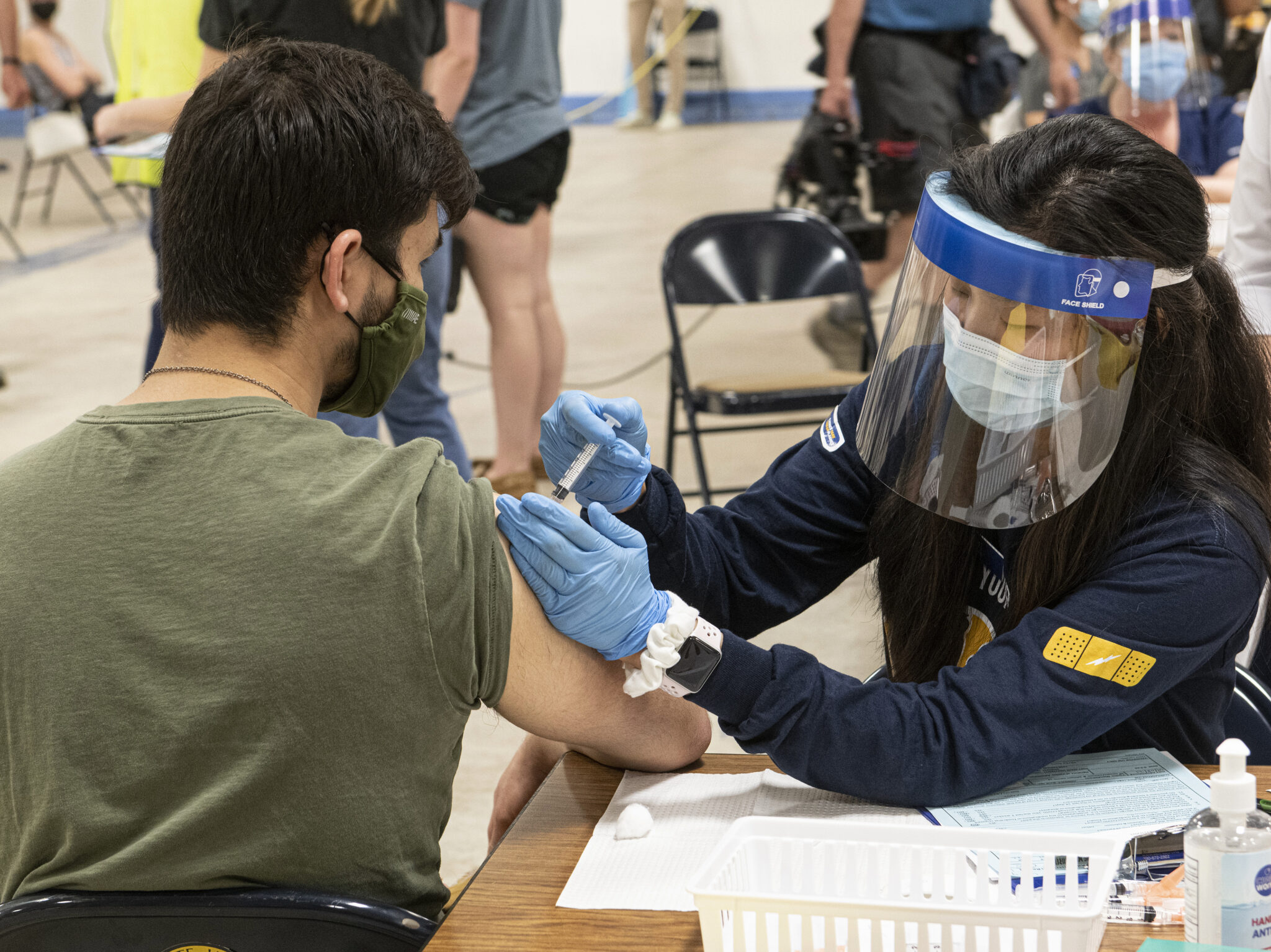 FILE - In this April 8, 2021, file photo, Kent State University student Jarrett Woo gets his Johnson & Johnson COVID-19 vaccination from Kent State nursing student Allie Rodriguez in Kent, Ohio. Even as restrictions relax across much of the United States, colleges and universities have taken new steps to police campus life as the virus spreads through students who are among the last adults to get access to vaccines. (AP Photo/Phil Long, File)