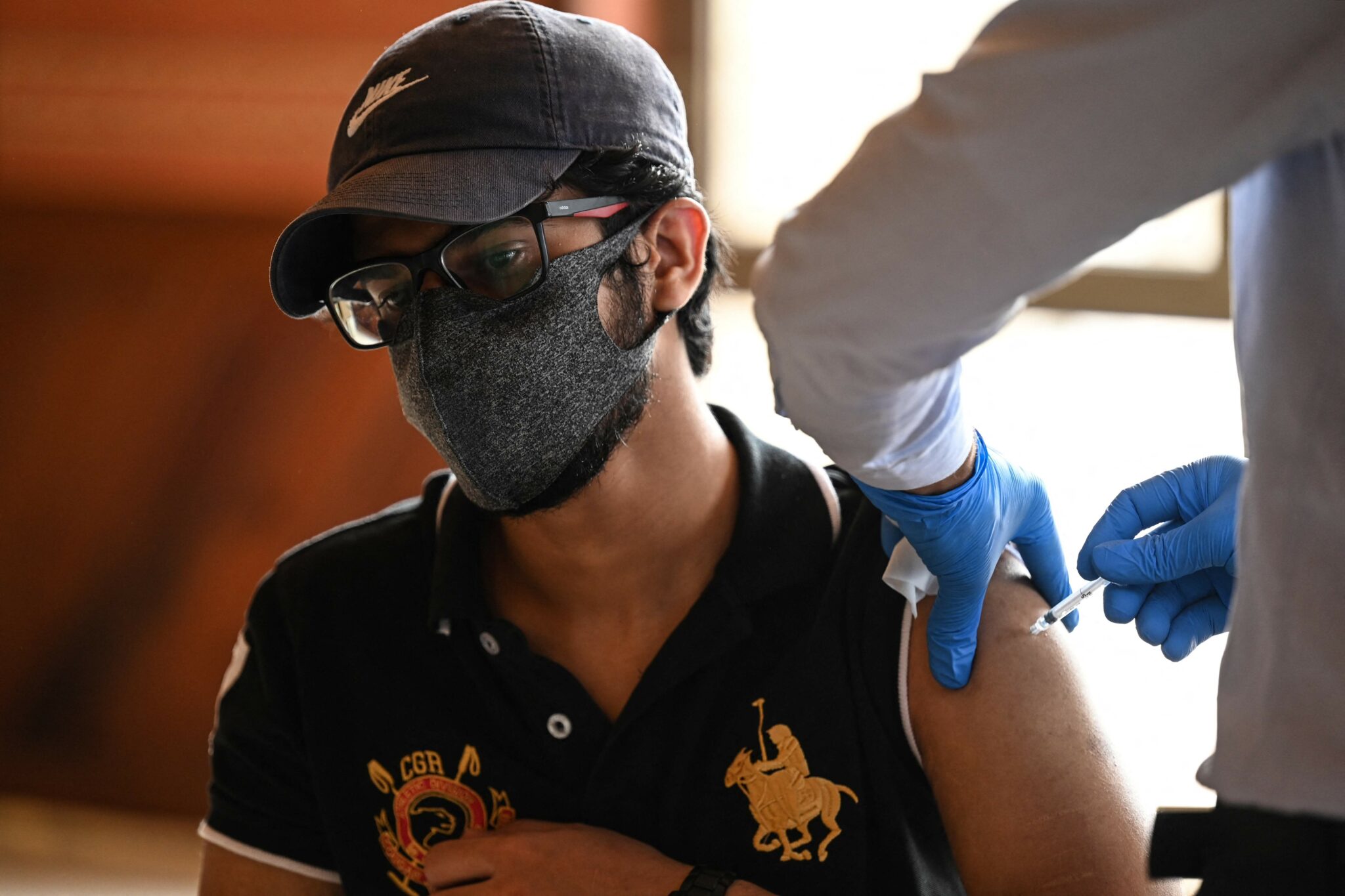 A youth receives a dose of the Covid-19 coronavirus Sinovac vaccine at a mass vaccination centre in Islamabad on June 3, 2021. / AFP / Aamir QURESHI