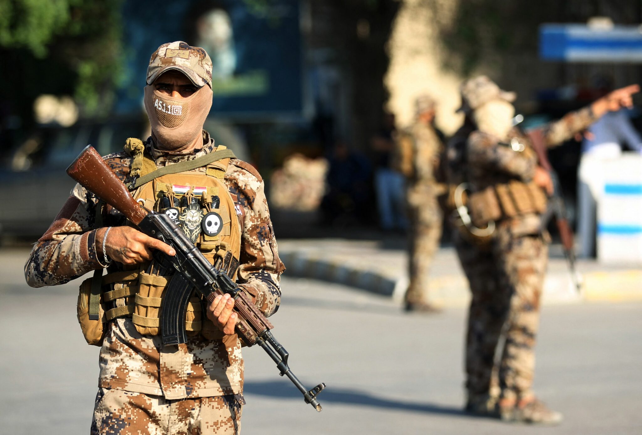 (FILES) In this file photo taken on October 26, 2019 Members of the Hashed al-Shaabi, or Popular Mobilisation Forces (PMF), paramilitaries stand guard during a funerary procession in the Iraqi capital Baghdad. Iraq's Hashed al-Shaabi paramilitary alliance said on June 28, 2021 that US air strikes had "resulted in the martyrdom of a group of heroic fighters" near the border with Syria, and threatened revenge. / AFP / AHMAD AL-RUBAYE