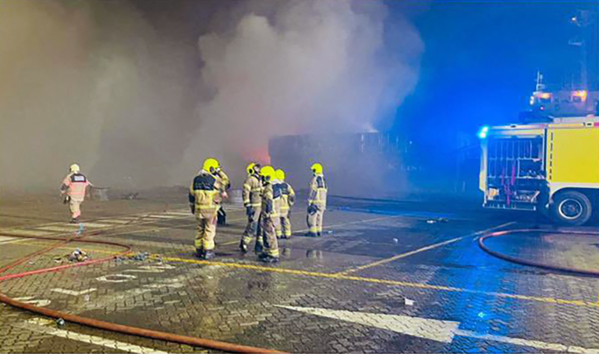 This handout picture provided by the Government of Dubai Media Office on July 8, 2021, shows civil defence firefighters at the scene of a blaze that broke out at Dubai's main port of Jebel Ali following an explosion. At least three residents in the area of the blast, the cause of which remains unknown, reported windows and doors in their homes were shaken as a result of the incident. The fire was caused by "an explosion within a container on board a ship" the Dubai Media Office wrote on Twitter. The vessel had been preparing to dock, the office added in an another post. - == RESTRICTED TO EDITORIAL USE - MANDATORY CREDIT "AFP PHOTO / HO / GOVERNMENT OF DUBAI MEDIA OFFICE" - NO MARKETING NO ADVERTISING CAMPAIGNS - DISTRIBUTED AS A SERVICE TO CLIENTS == / AFP / GOVERNMENT OF DUBAI MEDIA OFFICE / - / == RESTRICTED TO EDITORIAL USE - MANDATORY CREDIT "AFP PHOTO / HO / GOVERNMENT OF DUBAI MEDIA OFFICE" - NO MARKETING NO ADVERTISING CAMPAIGNS - DISTRIBUTED AS A SERVICE TO CLIENTS ==