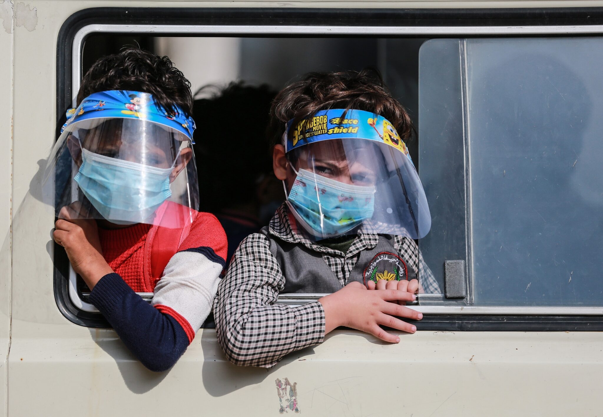 GAZA CITY, GAZA - NOVEMBER 17: Two kids wearing face masks and shields are seen on their way to school as the number of confirmed coronavirus cases has exceeded 1,000 and 11 more died of COVID-19 over the last 24 hours on November 17, 2020, in Gaza City, Gaza. (Photo by Mustafa Hassona/Anadolu Agency via Getty Images)