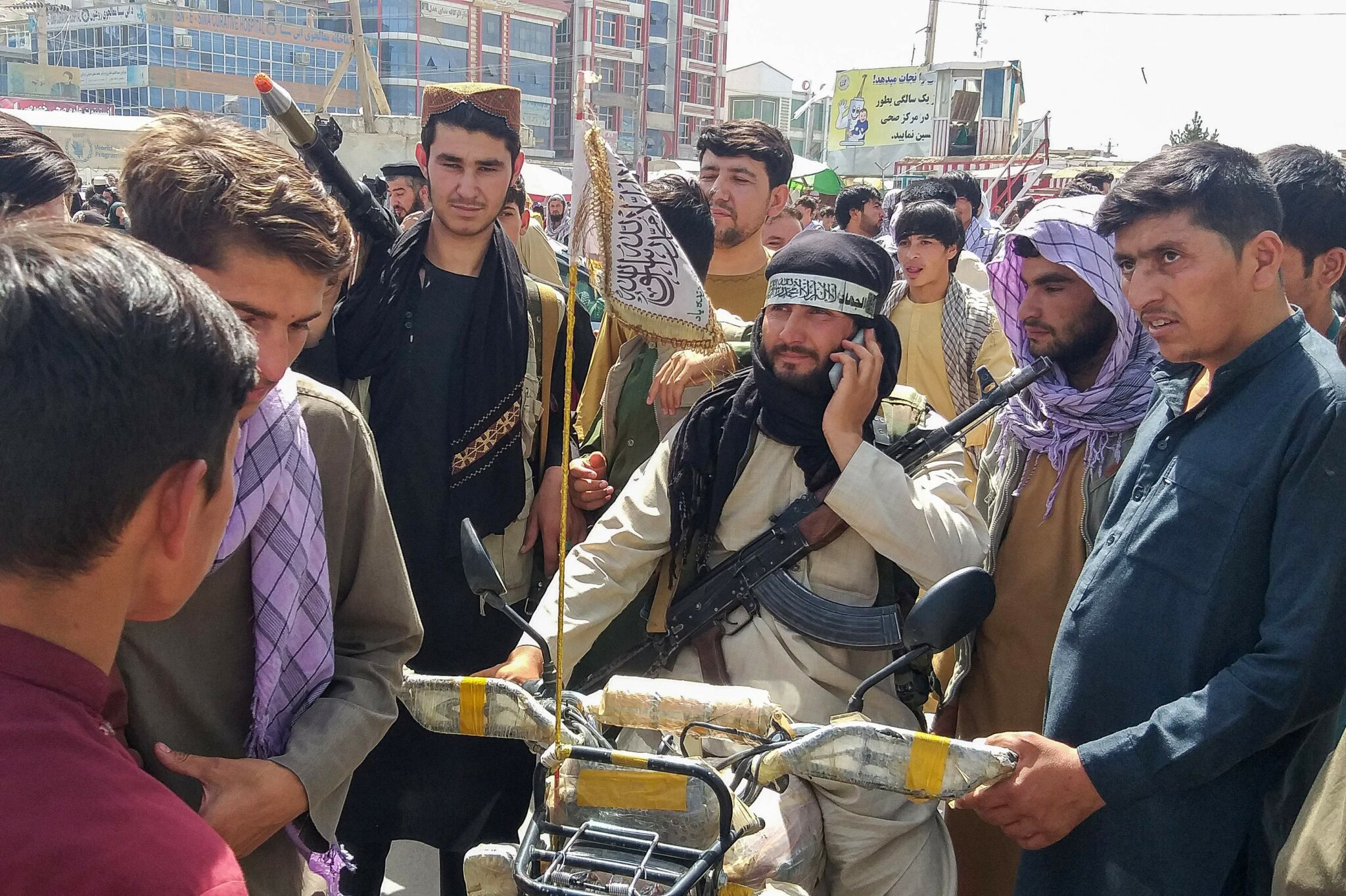 Taliban fighter (C) is seen surrounded by locals at Pul-e-Khumri on August 11, 2021 after Taliban captured Pul-e-Khumri, the capital of Baghlan province about 200 kms north of Kabul. (Photo by AFP)