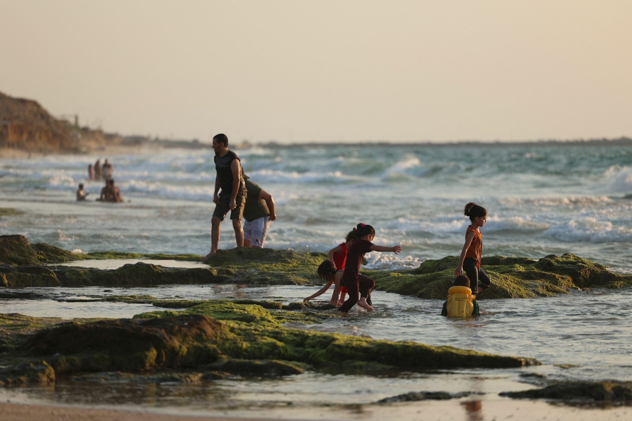 Palestinians bath in the Mediterranean Sea at Deir al-Balah beach in central Gaza Strip on August 12, 2021. (Photo by MOHAMMED ABED / AFP)