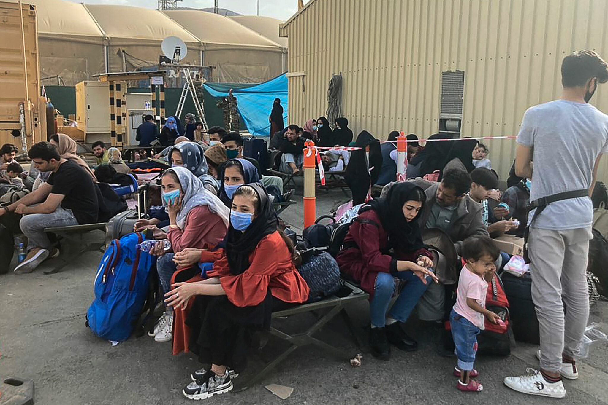 People wait to be evacuated from Afghanistan at the airport in Kabul on August 18, 2021 following the Taliban stunning takeover of the country. (Photo by AFP)