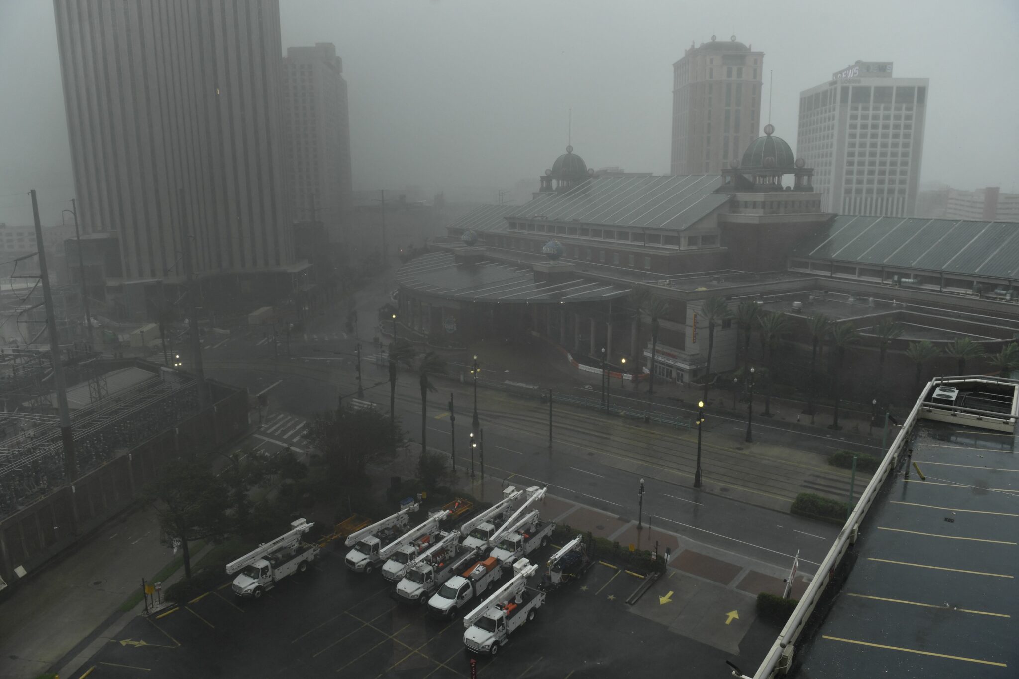 Utility vehicles sit on a lot as rain batters downtown New Orleans, Louisiana on August 29, 2021 after Hurricane Ida made landfall. "Extremely dangerous Category 4 Hurricane Ida makes landfall near Port Fourchon, Louisiana," the NHC wrote in an advisory on Sunday. Ida struck the port, which is located 100 miles (160 kilometers) directly south of New Orleans, at 1655 GMT, packing maximum sustained winds estimated at 150 miles per hour. (Photo by Patrick T. FALLON / AFP)