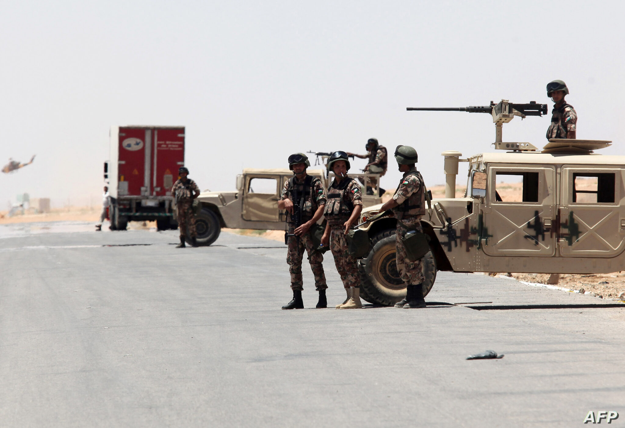 Jordanian soldiers stand guard near their military vehicles at the Al-Karameh border point with Iraq on June 25, 2014 as Jordan reinforced its border with Iraq after Sunni Arab militants overran a crossing with Syria. Sunni insurgents led by the jihadist Islamic State of Iraq and the Levant (ISIL) overran swathes of land north and west of Baghdad this month sparking fears in Amman that they will take the fight to Jordan, which is already struggling with its own home-grown Islamists. AFP PHOTO/STR