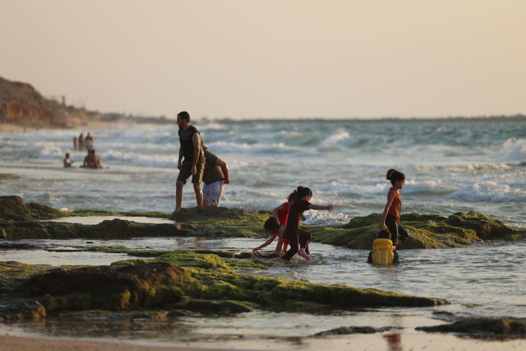 Palestinians bath in the Mediterranean Sea at Deir al-Balah beach in central Gaza Strip on August 12, 2021. (Photo by MOHAMMED ABED / AFP) (Photo by MOHAMMED ABED/AFP via Getty Images)