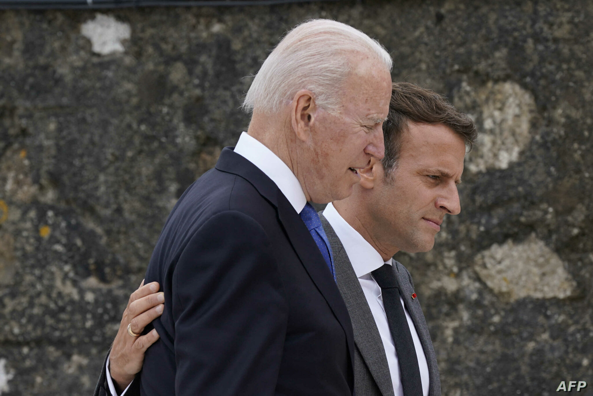 US President Joe Biden (L) talks with France's President Emmanuel Macron as they walk away after posing for the family photo at the start of the G7 summit in Carbis Bay, Cornwall on June 11, 2021. - G7 leaders from Canada, France, Germany, Italy, Japan, the UK and the United States meet this weekend for the first time in nearly two years, for three-day talks in Carbis Bay, Cornwall. (Photo by Patrick Semansky / POOL / AFP)