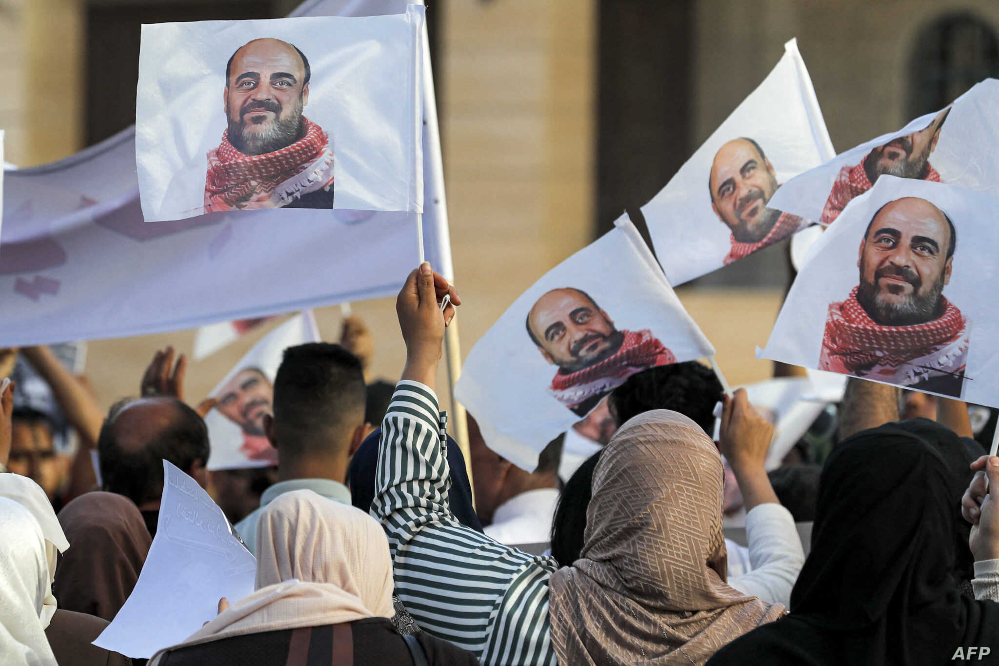 Demonstrators hold up images of late Palestinian activist Nizar Banat, who died in late June during a violent arrest by Palestinian Authority security forces, as they march during a protest in the city of Hebron in the occupied West Bank on July 13, 2021. (Photo by Ahmad GHARABLI / AFP)