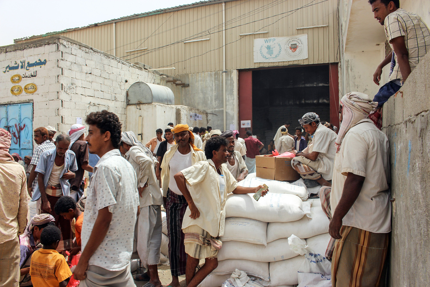 Yemeni civilians receive food aid for displaced people who fled battles in the Red Sea province of Hodeida and are now living in camps in the northern district of Abs, under control by the Iranian-backed Huthi rebels in Hajjah province, on June 24, 2018. (Photo by ESSA AHMED / AFP) (Photo credit should read ESSA AHMED/AFP/Getty Images)