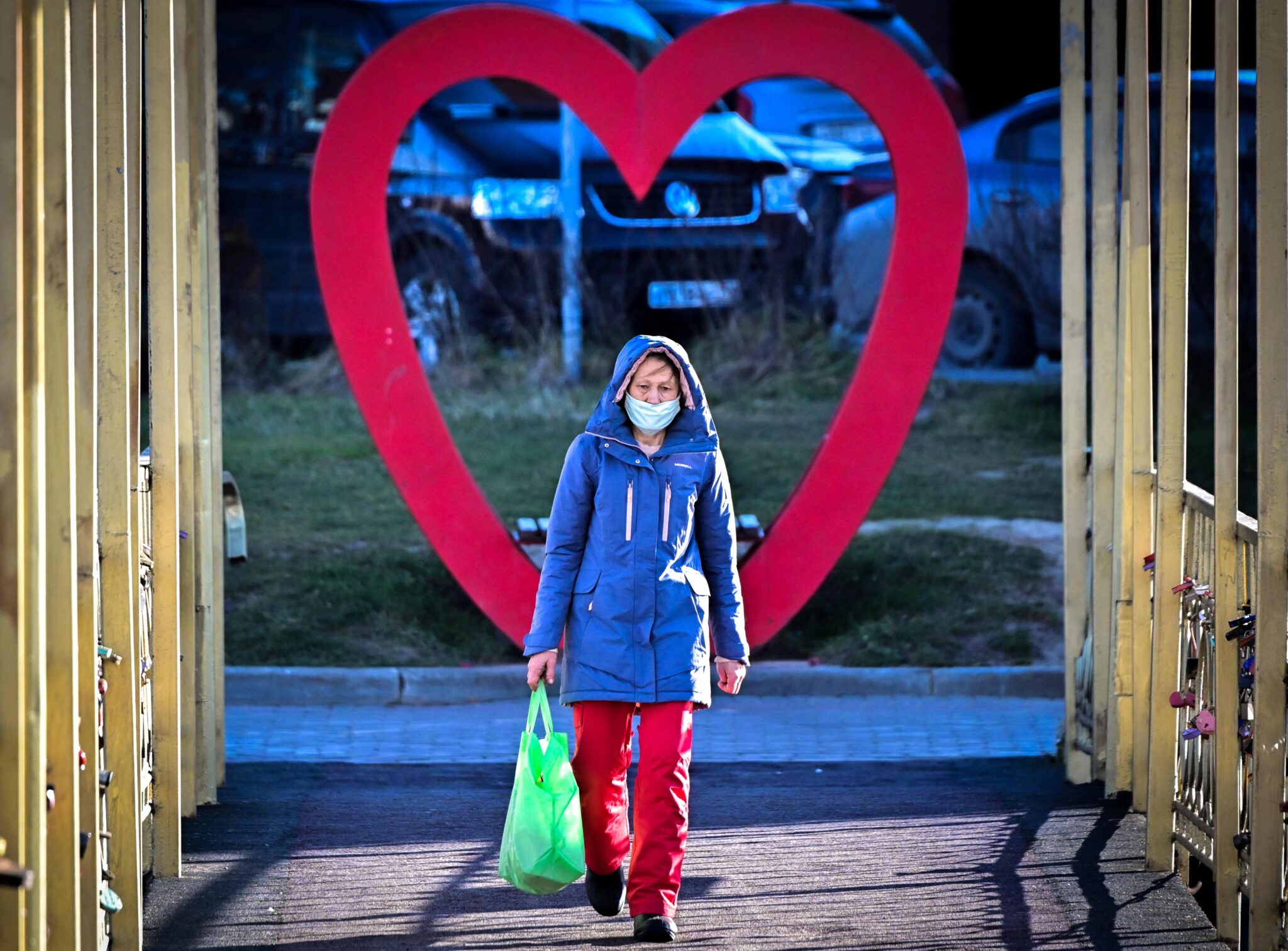 A woman wearing a face mask crosses a bridge in the town of Chekhov some 75 km outside Moscow on November 10, 2021. (Photo by Yuri KADOBNOV / AFP)