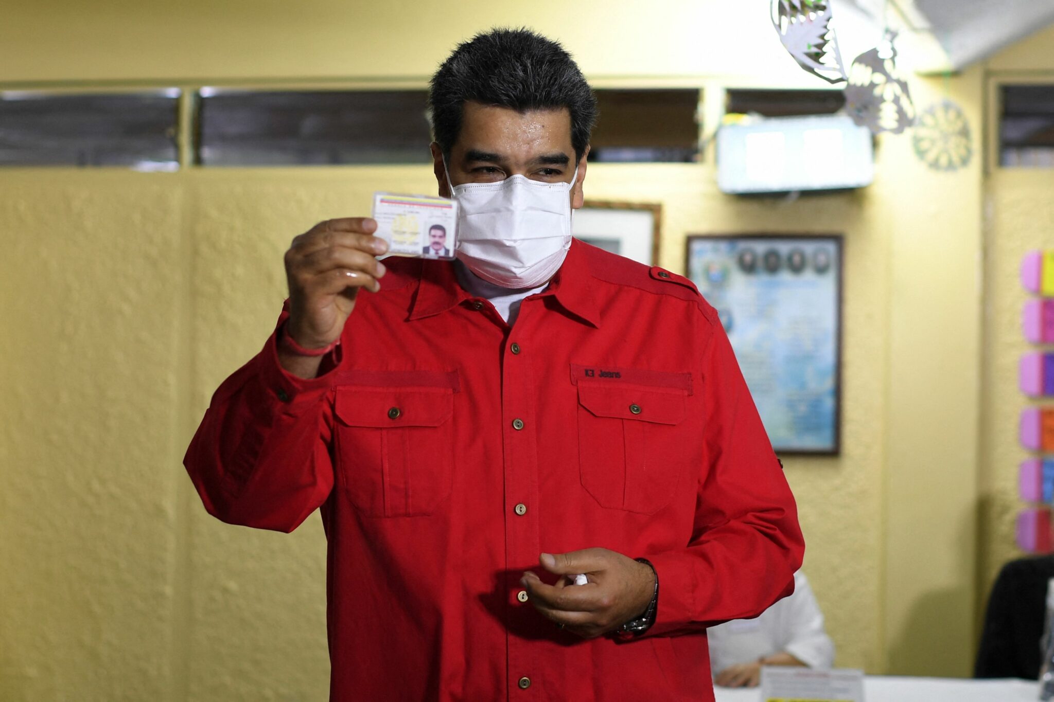 Venezuelan President Nicolas Maduro shows his ID after voting in a polling station during regional and municpal elections in Fuerte Tiuna in Caracas, on November 21, 2021. Venezuela elects governors and mayors this Sunday with the participation of the opposition, which breaks years of electoral boycott and calls for abstention, in a process that also brings the return of international observers after more than a decade of absence. (Photo by Yuri CORTEZ / AFP)