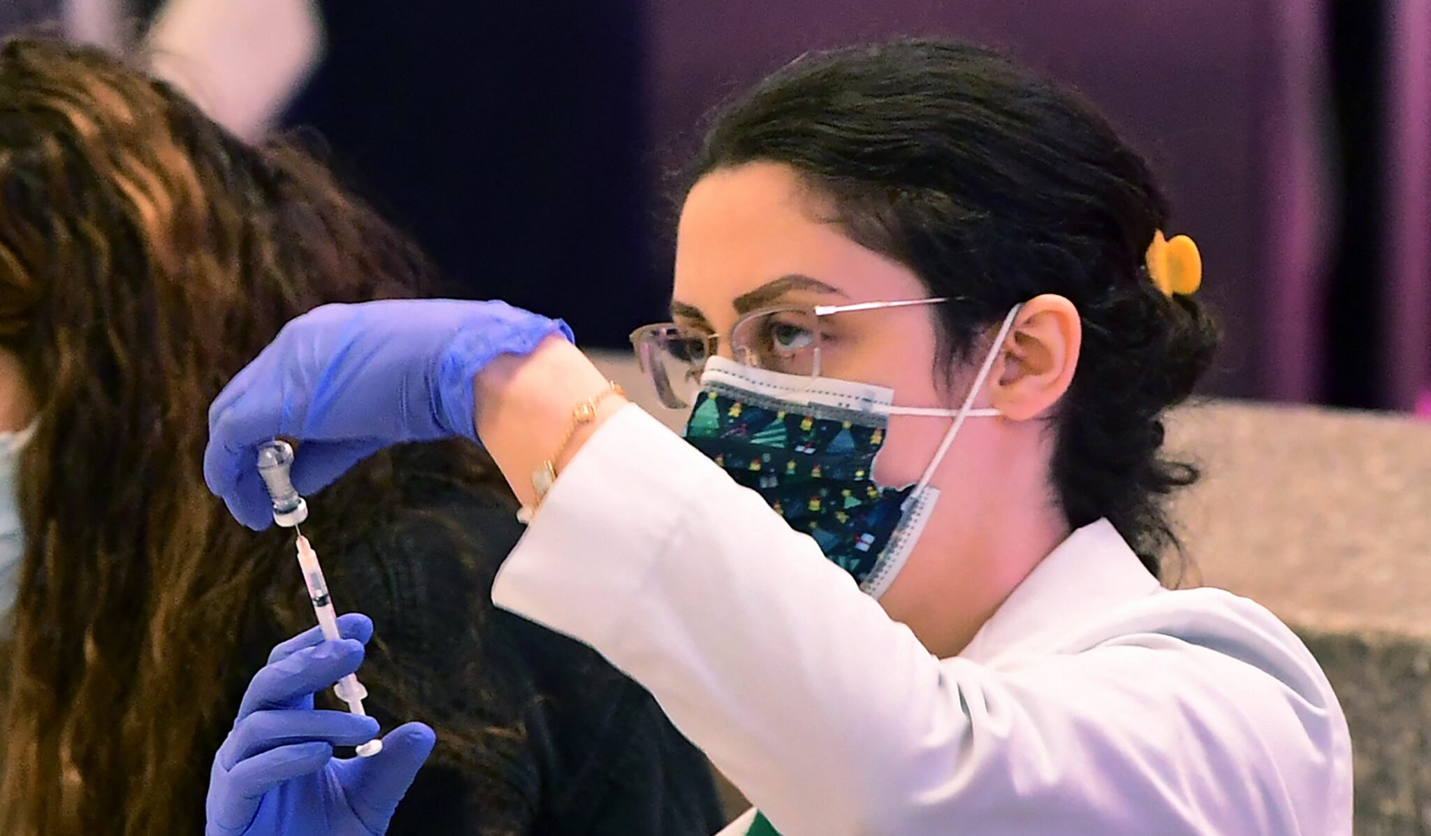 A pharmacist loads a syringe with the Covid-19 vaccine for administration at a pop-up clinic offering free vaccinations and booster shots in the international arrivals area of Los Angeles International Airport in Los Angeles on December 22, 2021. The clinic at the airport offers free vaccinations and boosters for holiday travelers on December 22 and on December 29. Los Angeles County sees what could be the beginning of a winter surge with more than 3,200 Covid-19 cases reported every day since last December 17. (Photo by Frederic J. BROWN / AFP)