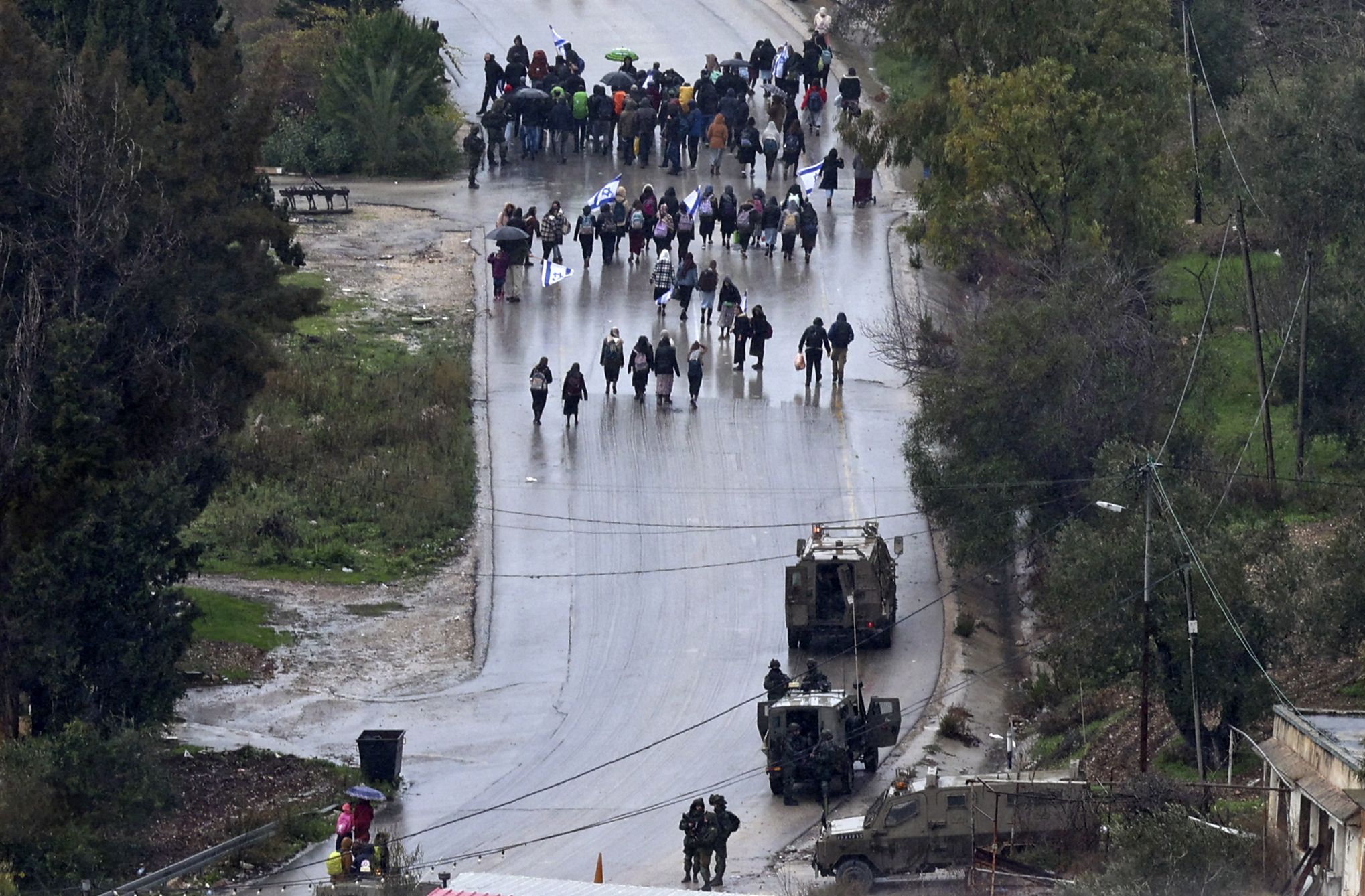 Israeli settlers return back to the illegal outpost of Homesh, after clashes between Israeli security forces and Palestinians, protesting the return of settlers to the area, in the occupied-West Bank village of Burqah, on December 23, 2021. Palestinian men are suspected by the Israeli army of firing at least 10 bullets at a car on December 16, killing 25-year-old religious student Yehuda Dimentman and wounding two fellow students as they drove out of Homesh, an illegal outpost in the northern West Bank. (Photo by JAAFAR ASHTIYEH / AFP)