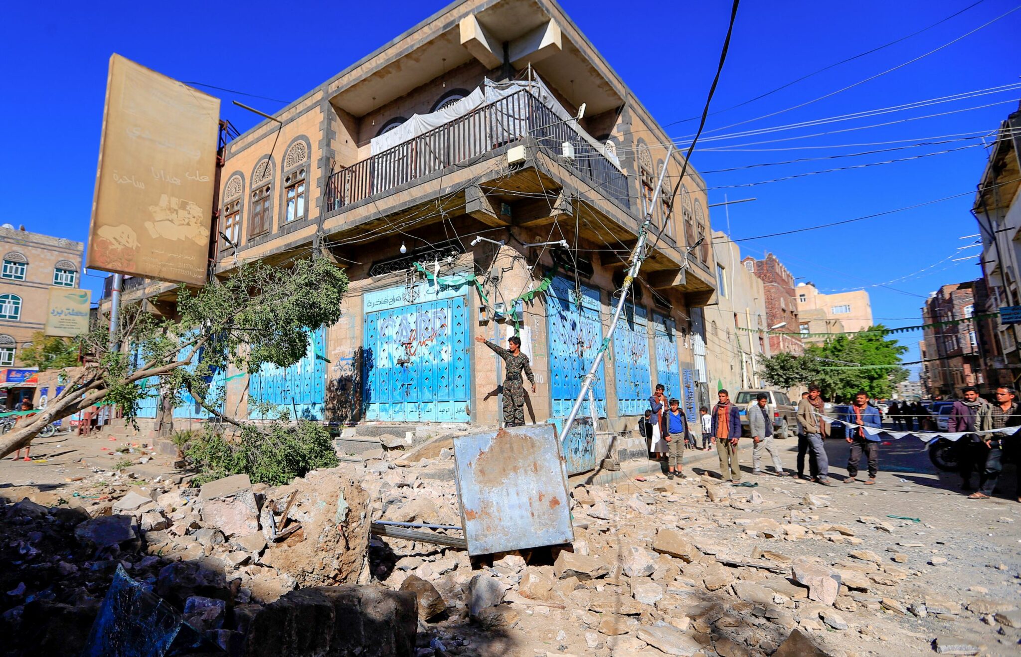 Yemenis inspect damage following a reported overnight air strike by the Saudi-led coalition targeting in the Huthi rebel-held capital Sanaa, on December 24, 2021. (Photo by MOHAMMED HUWAIS / AFP)