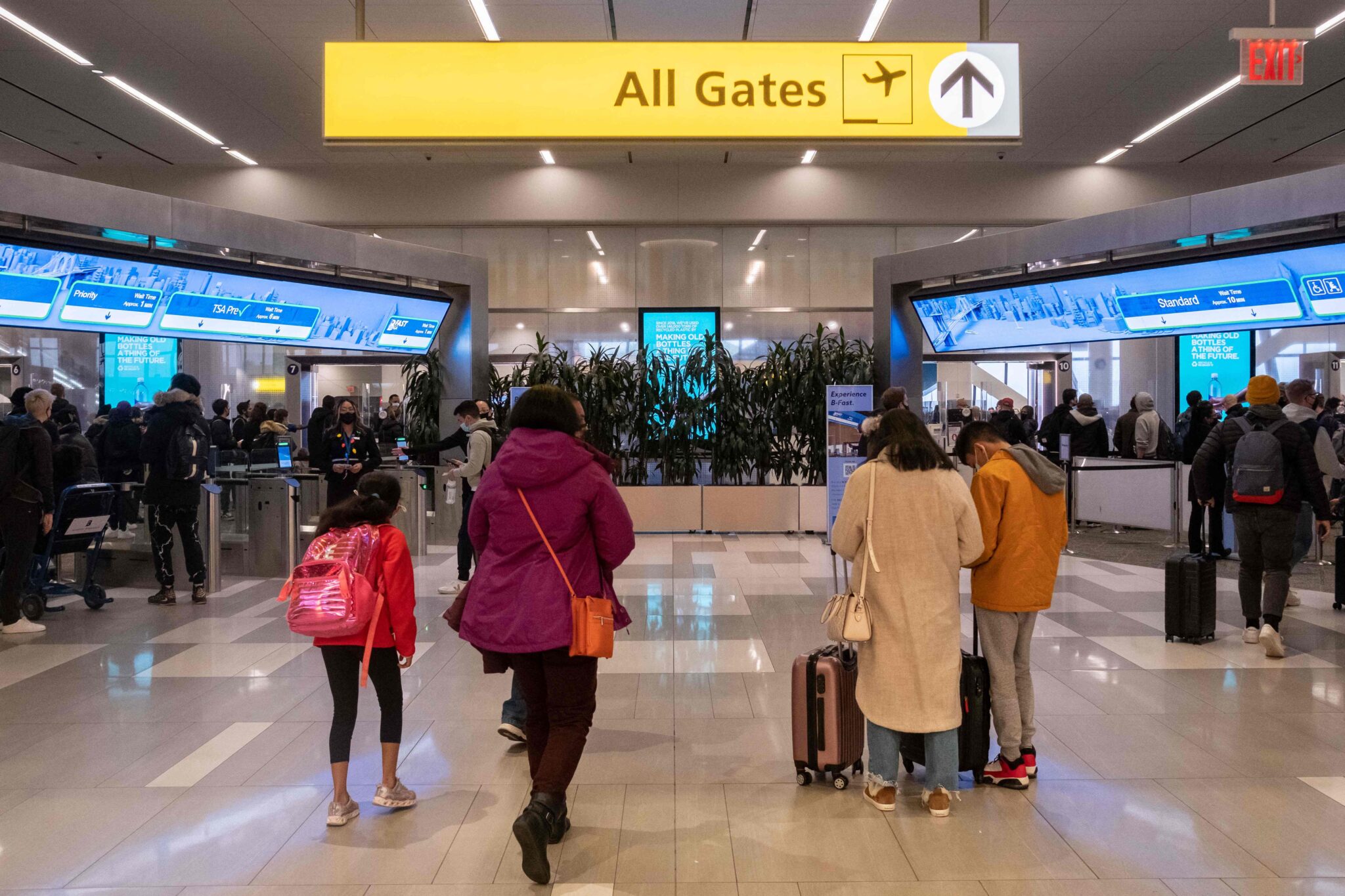 Travelers walk to a security check point at LaGuardia Airport in New York, on December 24, 2021. On Christmas Eve, airlines, struggling with the Omicron variant of Covis-19, have canceled over 2,000 flights globally, 454 of which are domestic, into or out of the US (Photo by Yuki IWAMURA / AFP)