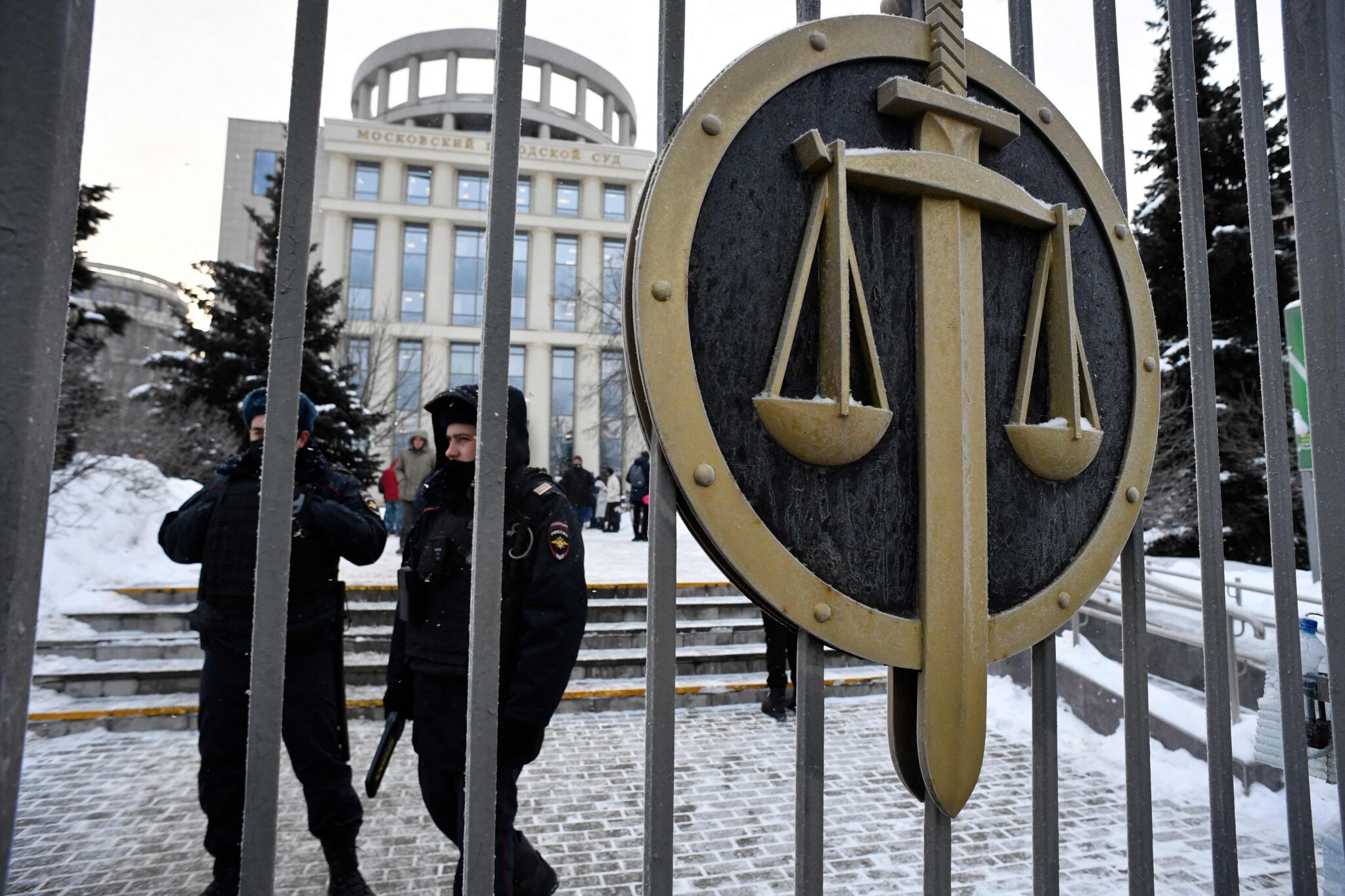 Police officers stand outside the Moscow City Court where a hearing over liquidation of Memorial's Human Rights Centre is ongoing, in Moscow on December 29, 2021. Moscow court hears case against Memorial's Human Rights Centre, after Russia's Supreme Court outlawed Memorial International on December 28, 2021. (Photo by Alexander NEMENOV / AFP)