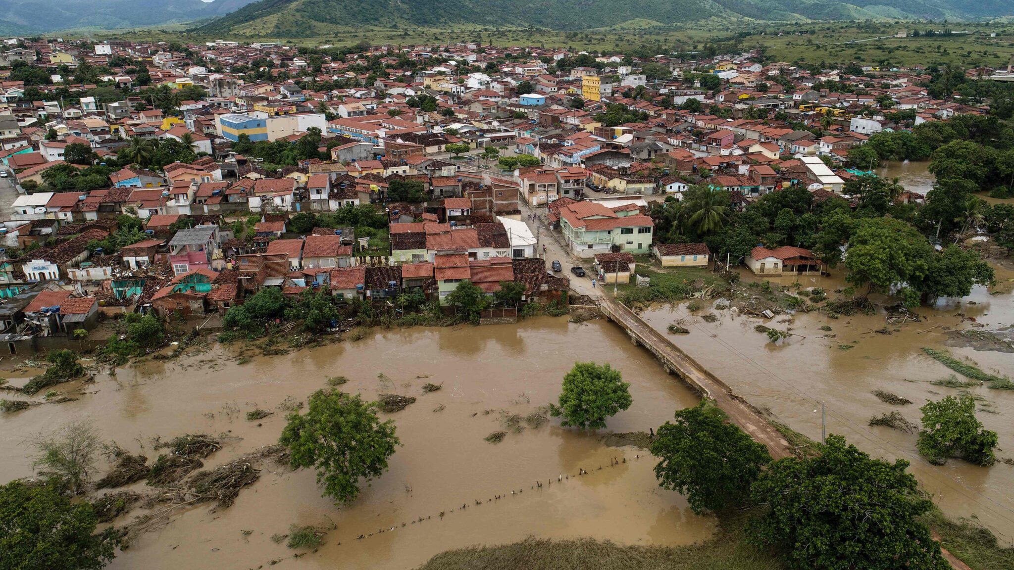 TOPSHOT - Aerial view showing a flooded area of Itambe caused by heavy rainfall in the Brazilian state of Bahia State, taken on December 29, 2021. Bahia State faces a heavy cost from the flooding caused by torrential rains that burst two dams and left at least 21 people dead. (Photo by RICARDO DUTRA / AFP)