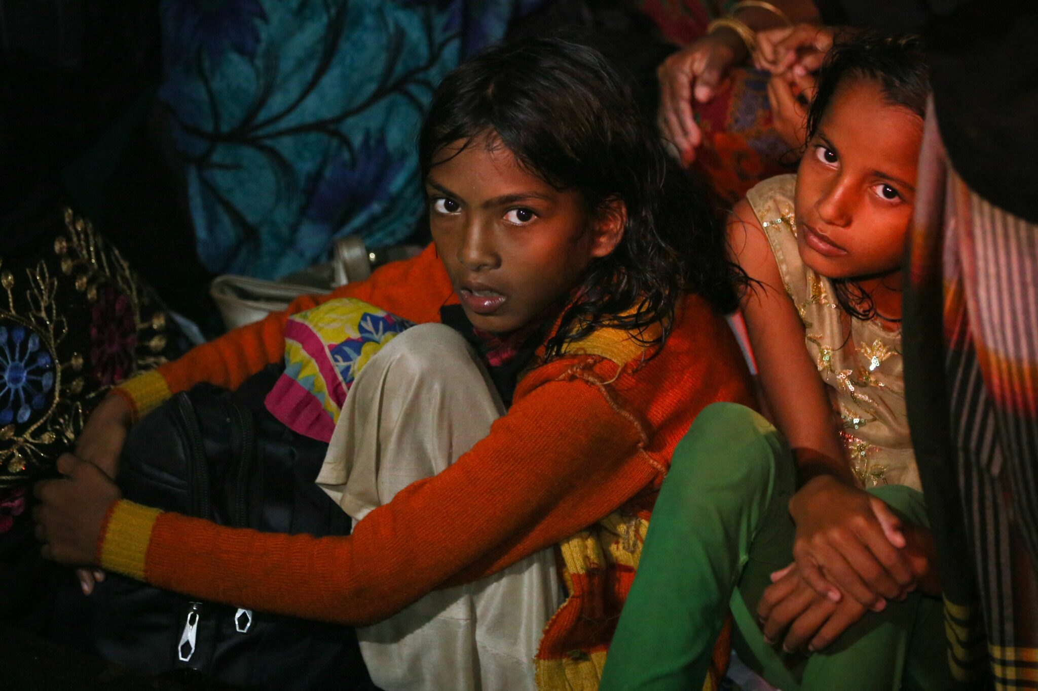 Rohingya refugees sit on a wooden boat at the Krueng Geukueh port in Lhokseumawe, Aceh province on December 31, 2021, after they were rescued by Indonesia's navy in the waters off Bireuen. (Photo by AMANDA JUFRIAN / AFP)