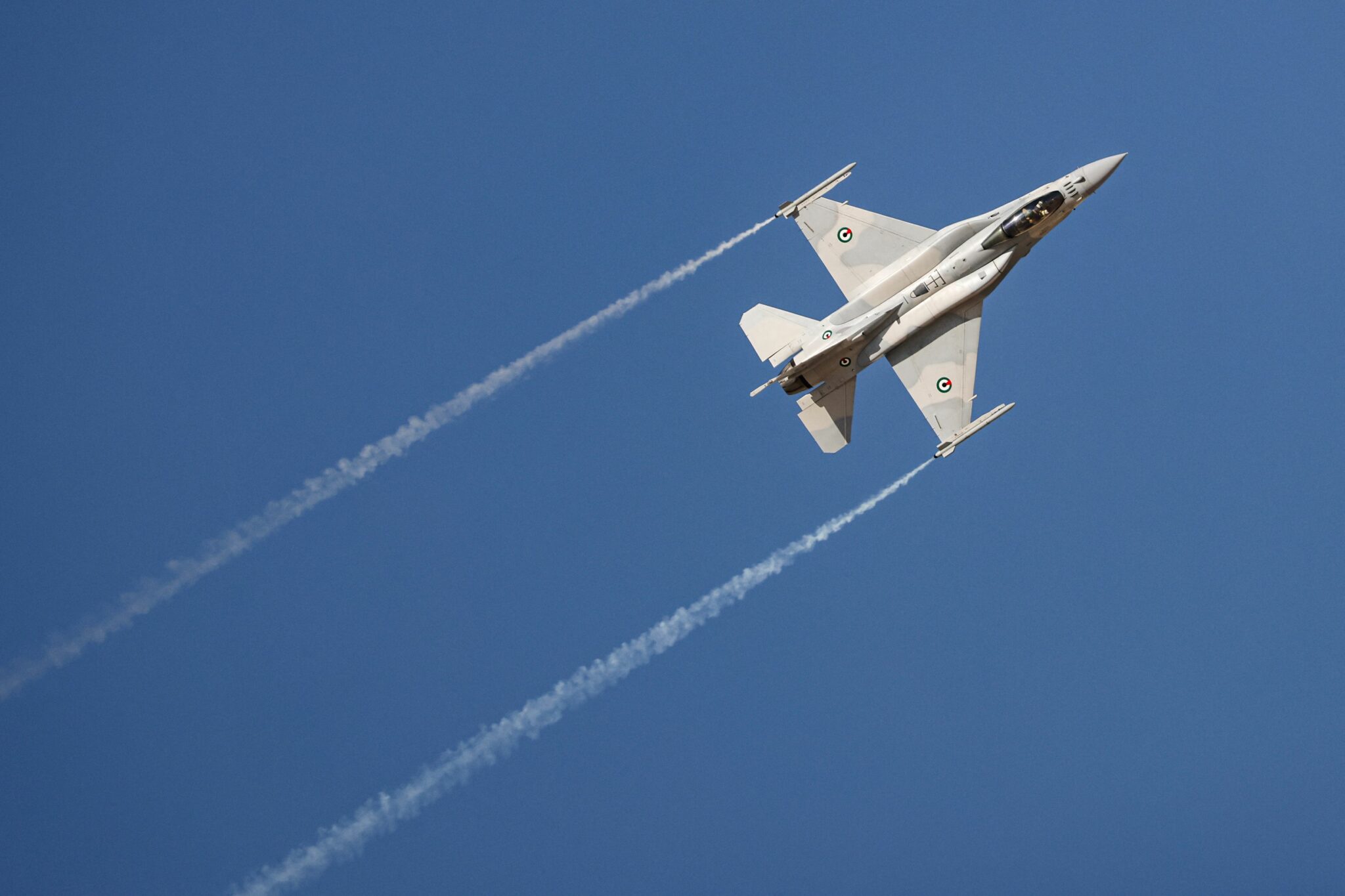 A UAE Air Force General Dynamics F-16 Fighting Falcon multirole fighter aircraft performs aerial manuevers during the 2021 Dubai Airshow in the Gulf emirate on November 14, 2021. (Photo by Giuseppe CACACE / AFP)