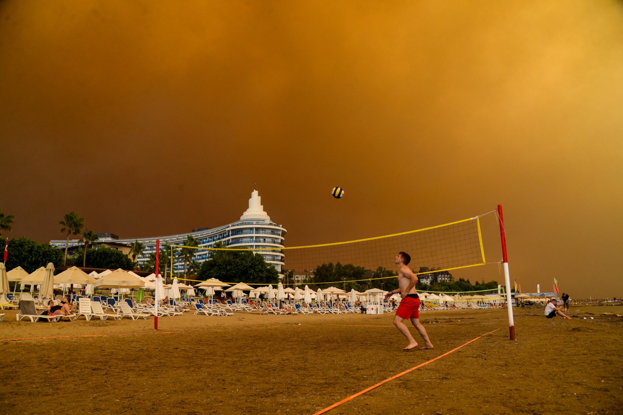 -- AFP PICTURES OF THE YEAR 2021 -- Dark smoke drifts over a hotel complex during a massive forest fire which engulfed a Mediterranean resort region on Turkey's southern coast near the town of Manavgat, on July 29, 2021. At least three people were reported dead on July 29, 2021 and more than 100 injured as firefighters battled blazes engulfing a Mediterranean resort region on Turkey's southern coast. Officials also launched an investigation into suspicions that the fires that broke out Wednesday in four locations to the east of the tourist hotspot Antalya were the result of arson. - AFP PICTURES OF THE YEAR 2021 (Photo by Ilyas AKENGIN / AFP) / AFP PICTURES OF THE YEAR 2021