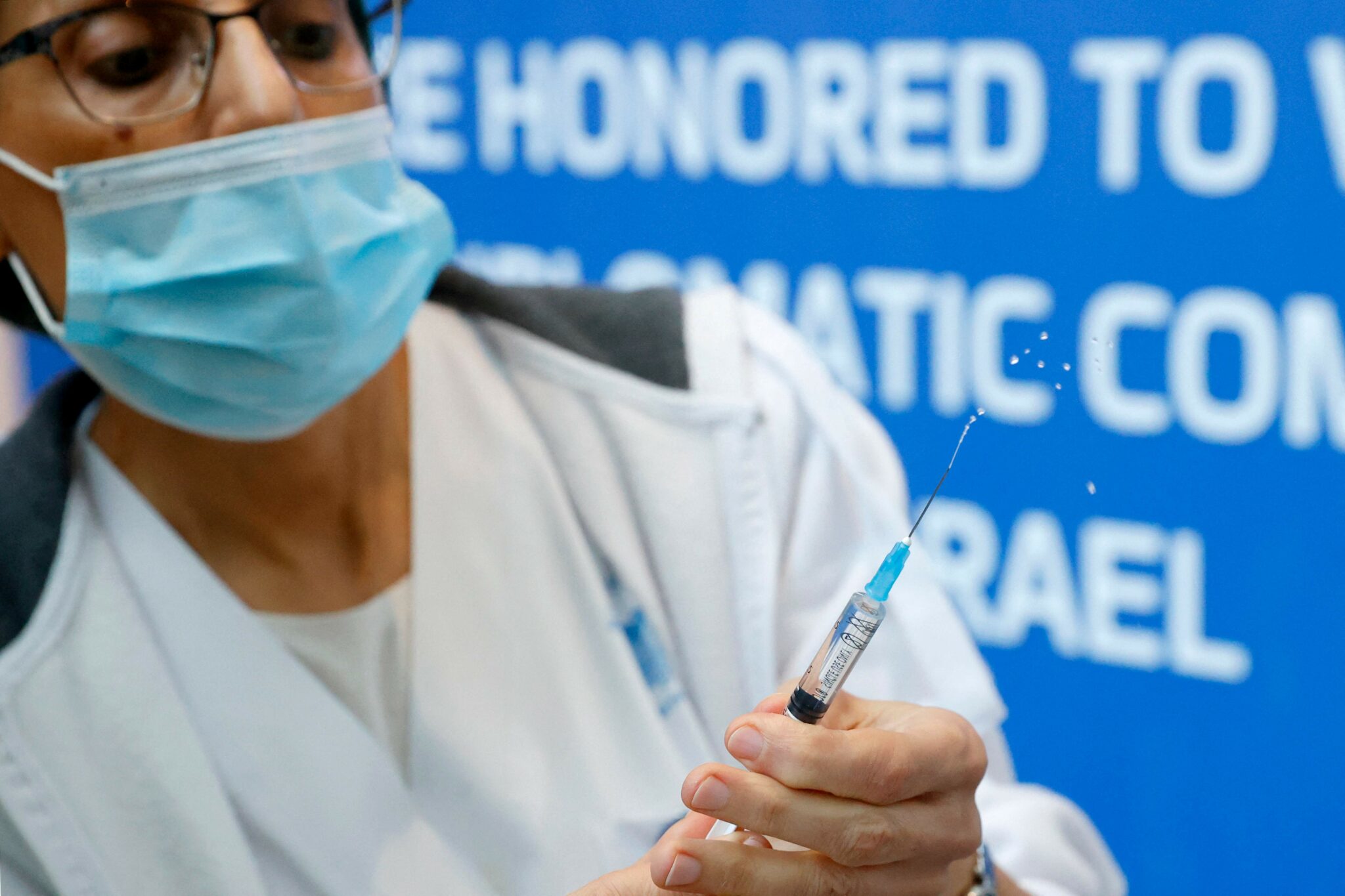 A medic prepares a dose of the Pfizer-BioNTech COVID-19 coronavirus vaccine at Ichilov Tel Aviv Sourasky Medical Centre in Israel's Mediterranean coastal city of Tel Aviv on January 3, 2022. (Photo by JACK GUEZ / AFP)