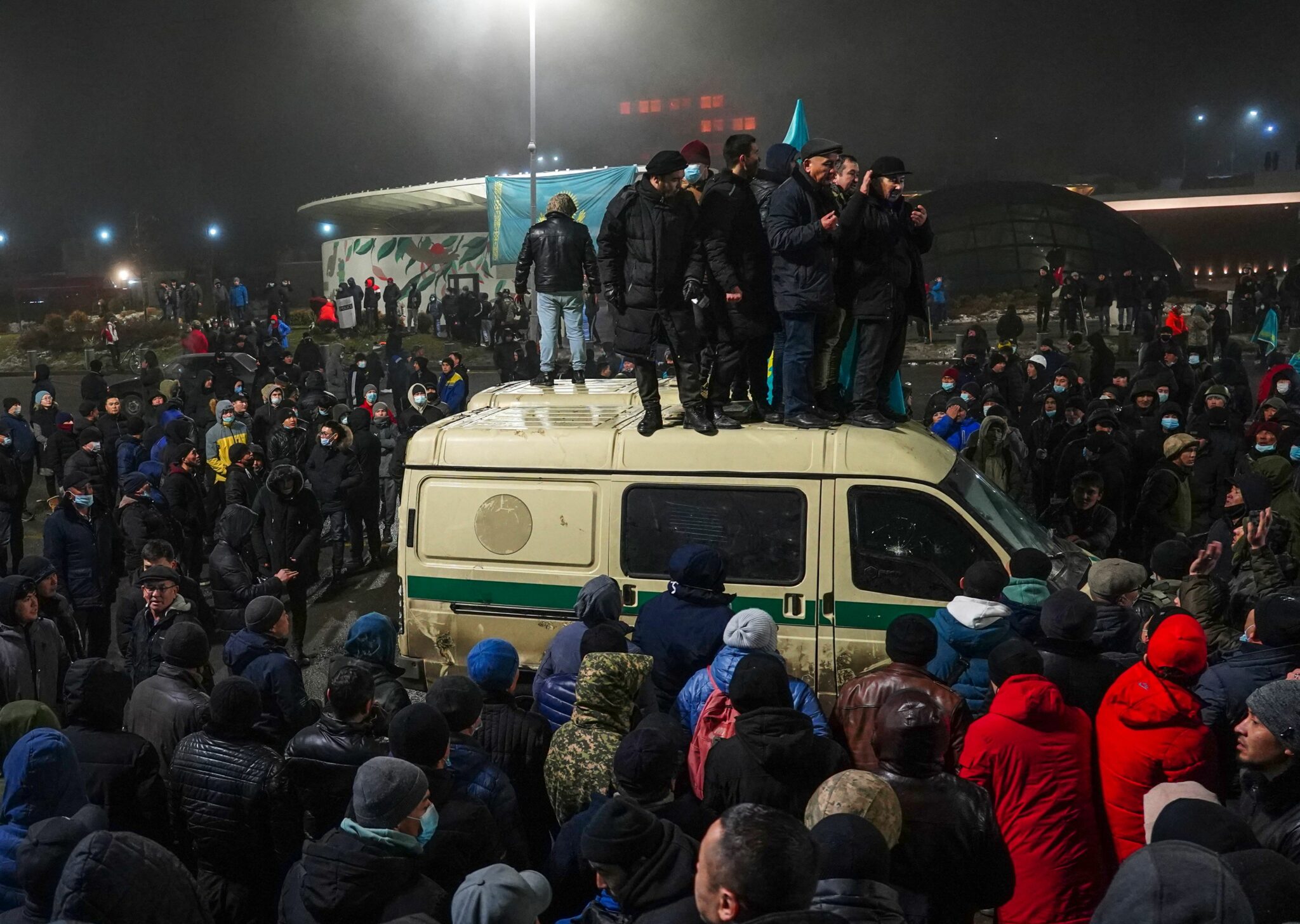 TOPSHOT - Protesters take part in a rally over a hike in energy prices in Almaty on January 5, 2022. Kazakhstan on January 5, 2022 declared a nationwide state of emergency after protests over a fuel price hike erupted into clashes and saw demonstrators storm government buildings. (Photo by Abduaziz MADYAROV / AFP)