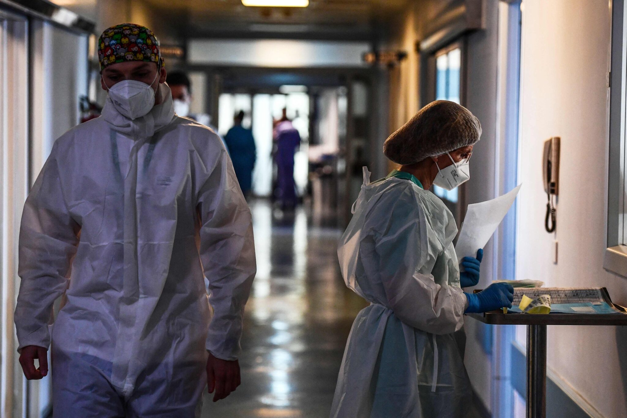 Medical staff members walk in a corridor at the Covid-19 intensive care unit of Cremona hospital, in Cremona, northern Italy, on January 11, 2022. Italy's Prime Minister Mario Draghi put the pressure back on the unvaccinated on January 10, 2022, calling them the cause of "most of the problems" in the country, which has been plagued by the spread of the Omicron variant. (Photo by Miguel MEDINA / AFP)