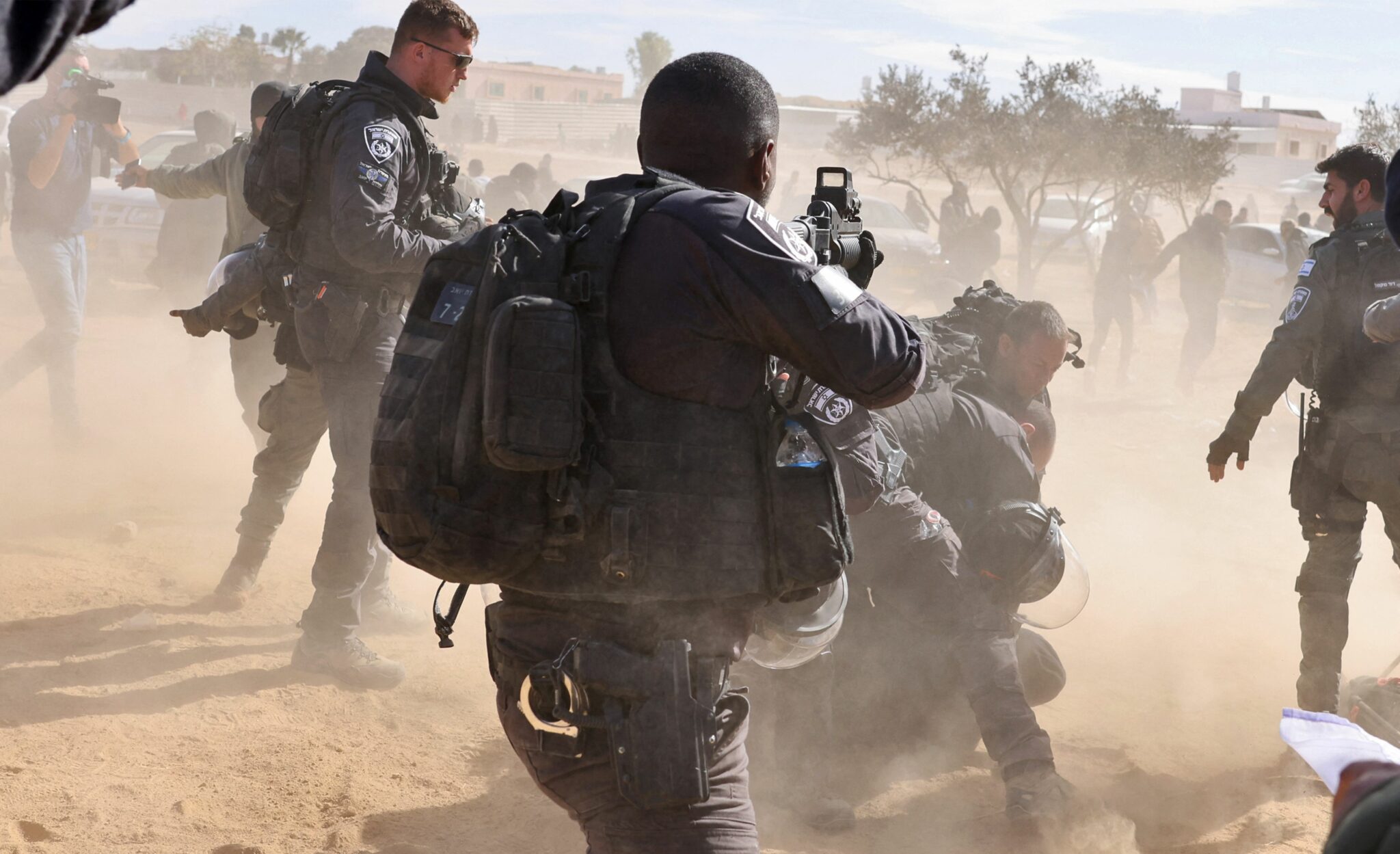 TOPSHOT - Israeli police detain a man as Bedouins protest in the southern Israeli village of Sawe al-Atrash in the Neguev Desert against an afforestation project by the Jewish National Fund (JNF), on January 12, 2022. Israel's government today sought to ease tensions with Bedouins over a controversial tree-planting project in the Negev desert, following days of unrest that marked the latest test for the fragile coalition (Photo by AHMAD GHARABLI / AFP)