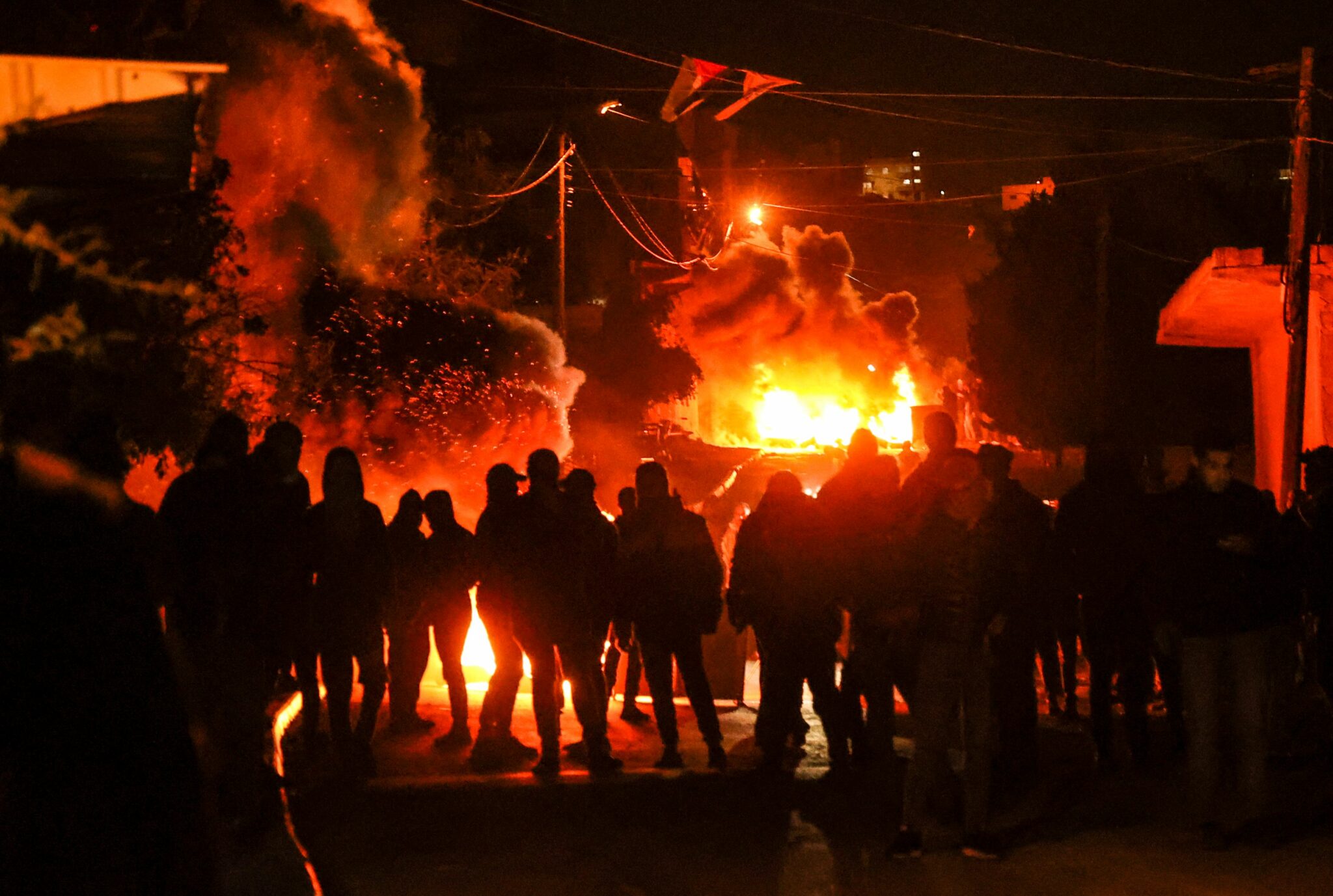 Palestinians clash with Israeli security forces, following a demonstration against the return of Jewish settlers to the illegal Israeli outpost of Homesh, near the Palestinian village of Burqah in the occupied West Bank, on January 13, 2022. (Photo by JAAFAR ASHTIYEH / AFP)