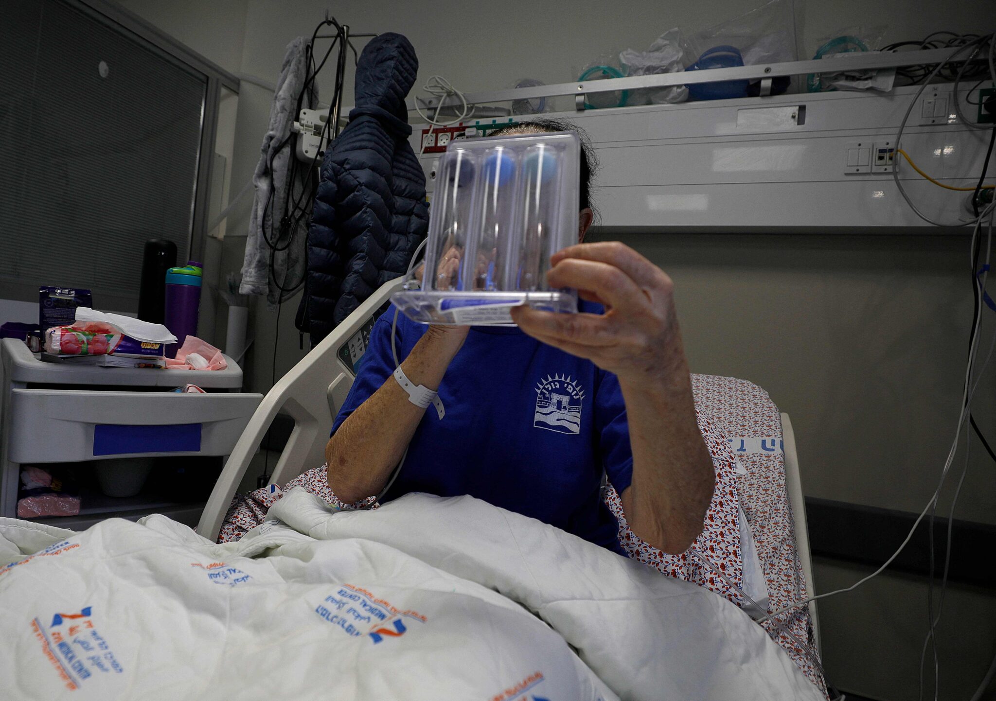 An Israeli Covid-19 patient uses a Spirometer for breathing exercise inside a coronavirus isolation ward at the Ziv Medical Centre in the city of Safed in northern Israel on January 16, 2022. Israel's response to the Covid pandemic has been closely watched worldwide, notably for its rapid vaccine rollout and early decision to offer booster shots before there was broad scientific support for a third dose. The country is now confronting an unprecedented caseload fuelled by the Omicron variant, with more than 37,000 new cases reported Tuesday, shattering previous records. (Photo by JALAA MAREY / AFP)