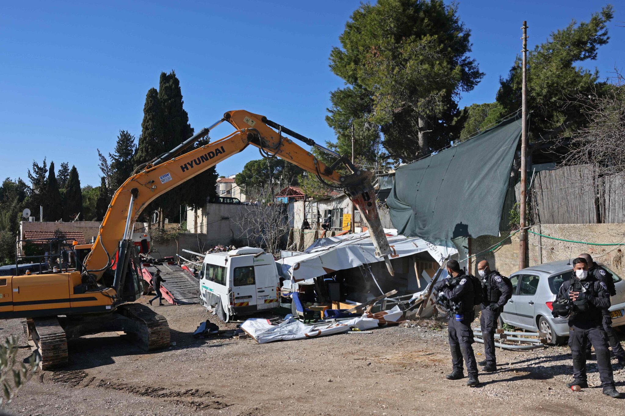 Israeli police drill around a house belonging to a Palestinian family facing eviction in the east Jerusalem neighbourhood of Sheikh Jarrah, on January 17, 2022. (Photo by AHMAD GHARABLI / AFP)