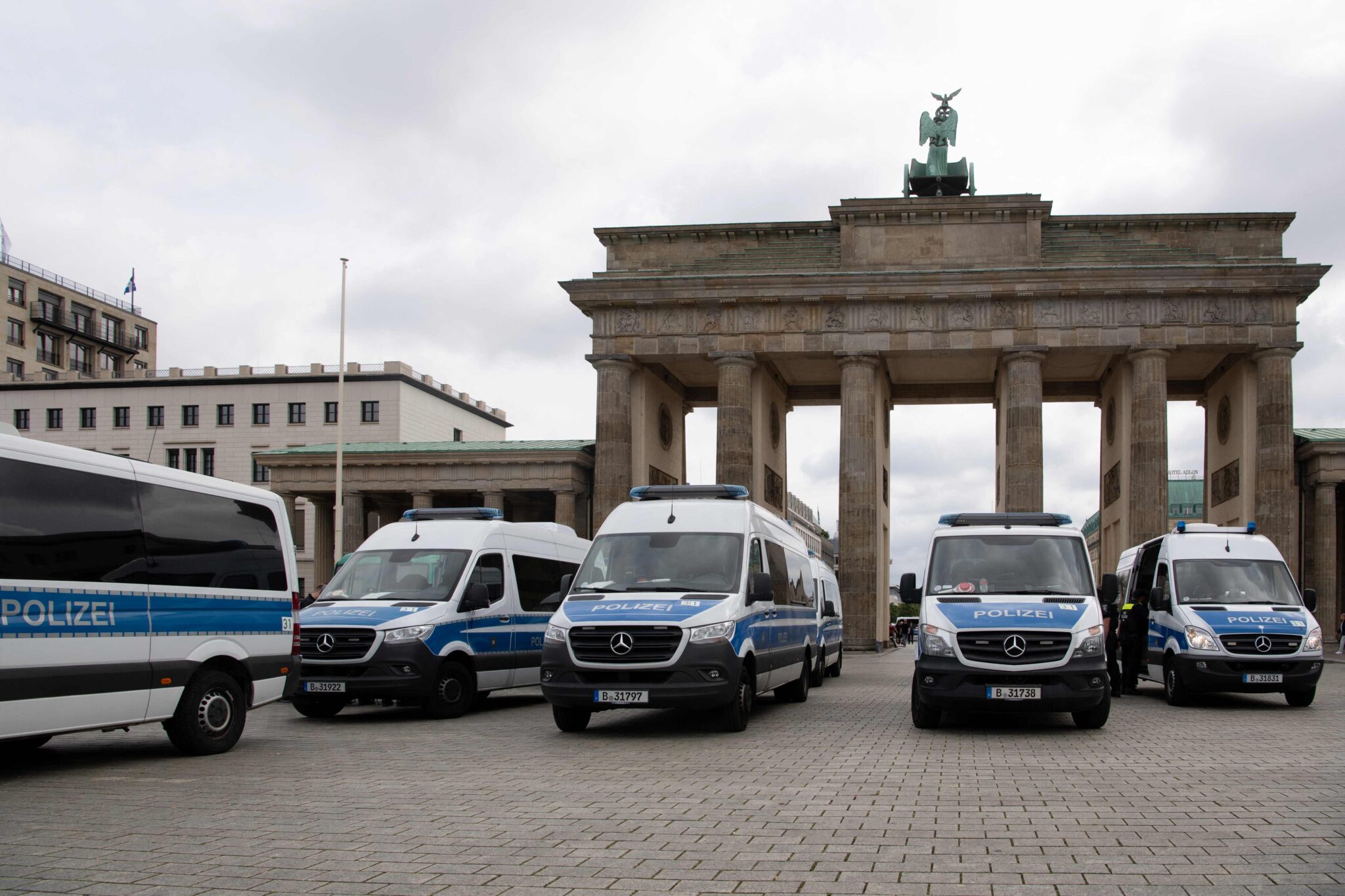 Police cars are seen in front of the landmark Brandenburg Gate during anti-lockdown protests in Berlin on August 1, 2021. Berlin police clashed with Covid sceptics on August 1 after hundreds of them took to the streets despite a court-ordered protest ban over concerns participants would not respect rules on mask-wearing and social distancing. (Photo by Paul ZINKEN / AFP)