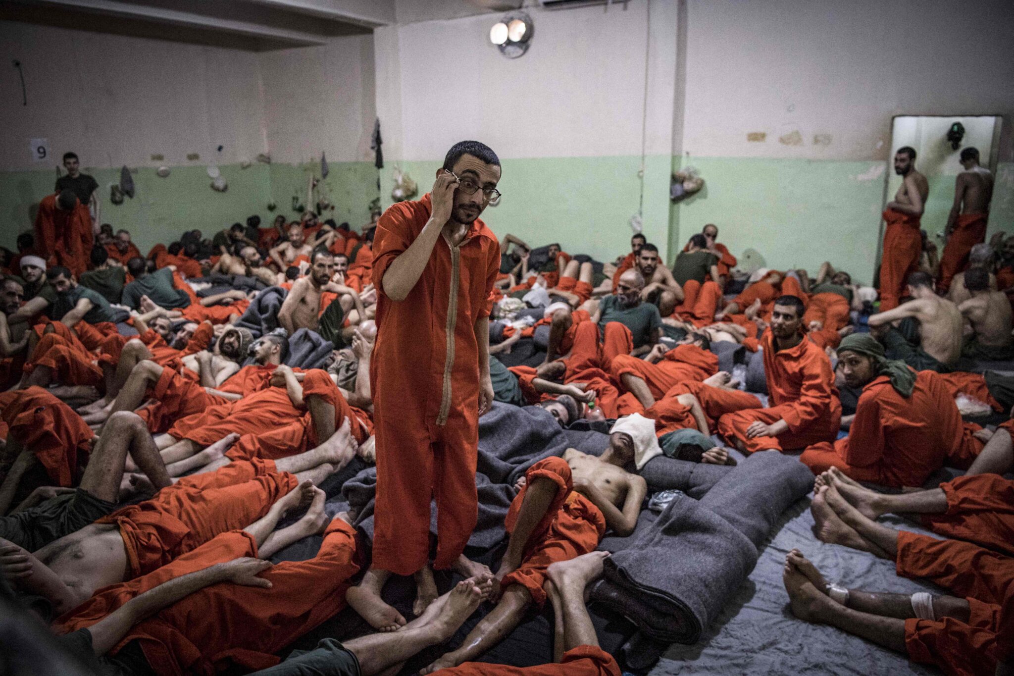 (FILES) This file photo taken on October 26, 2019, shows men suspected of being affiliated with the Islamic State (IS) group, gathered in a cell of the Sinaa prison in the Ghwayran neighbourhood of the northeastern Syrian city of Hasakeh. The Islamic State group (IS) attacked a Kurdish-run jail in northeast Syria today, freeing fellow jihadists, a war monitor reported without specifying how many escaped. (Photo by FADEL SENNA / AFP)