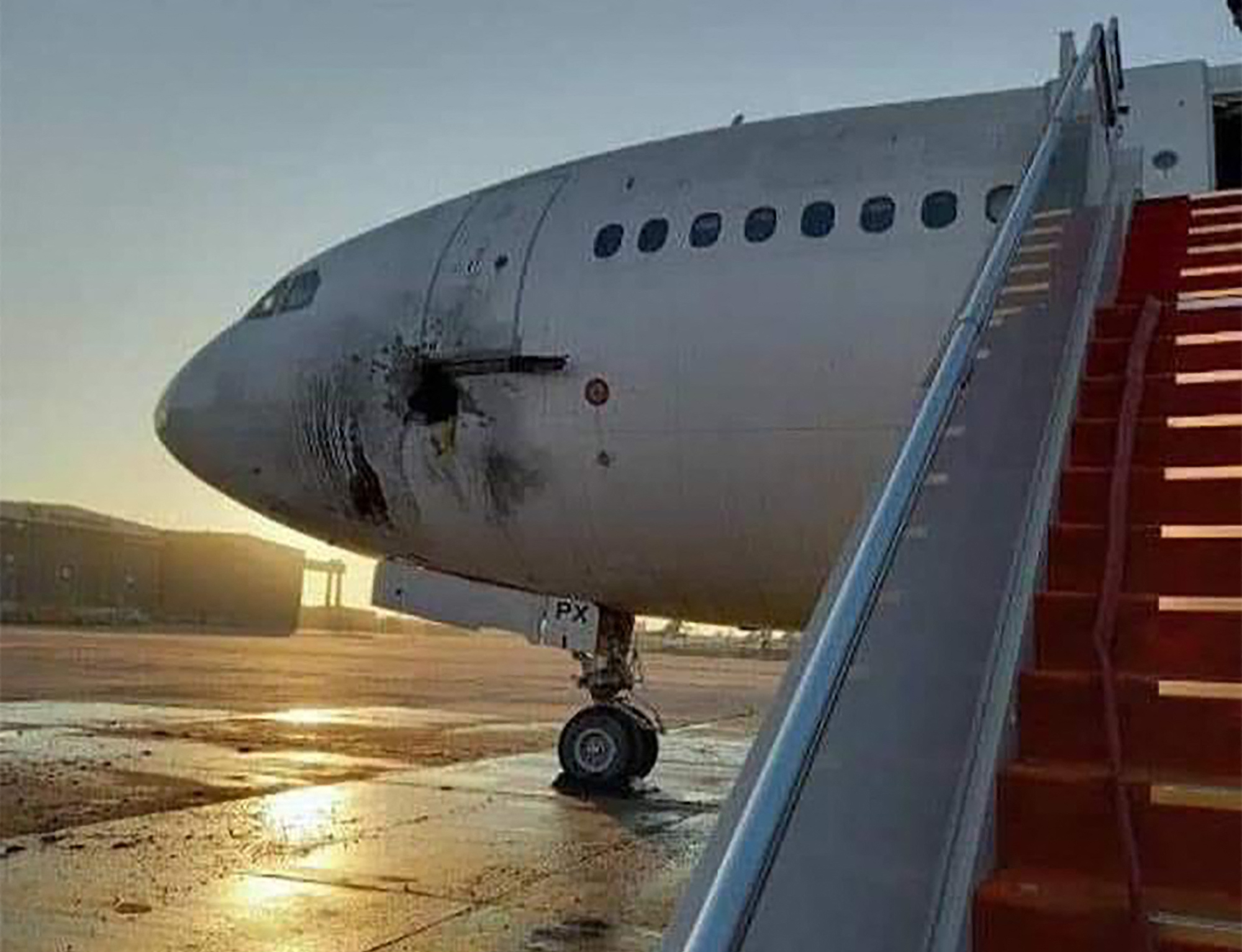 TOPSHOT - A handout picture released by the Facebook page of the Iraqi ministry of transportation, shows a damaged stationary aircraft on the tarmac of Baghdad airport, after rockets reportedly tragetted the runway, on January 28, 2022. Six rockets were fired at the Iraqi capital's airport at dawn today, causing damage to a plane but no casualties, two security sources said. - === RESTRICTED TO EDITORIAL USE - MANDATORY CREDIT "AFP PHOTO / HO / FACEBOOK PAGE OF THE IRAQI MINISTRY OF TRANSPORTATION" - NO MARKETING NO ADVERTISING CAMPAIGNS - DISTRIBUTED AS A SERVICE TO CLIENTS === (Photo by FACEBOOK PAGE OF THE IRAQI MINISTRY OF TRANSPORTATION / AFP) / === RESTRICTED TO EDITORIAL USE - MANDATORY CREDIT "AFP PHOTO / HO / FACEBOOK PAGE OF THE IRAQI MINISTRY OF TRANSPORTATION" - NO MARKETING NO ADVERTISING CAMPAIGNS - DISTRIBUTED AS A SERVICE TO CLIENTS ===