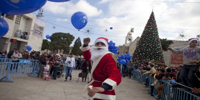 BETHLEHEM, WEST BANK - DECEMBER 24: A Palestinian man dresses in a Santa Claus costume outside the Church of the Nativity on December 24, 2014 in Bethlehem, West Bank. Every Christmas pilgrims travel to the church where a gold star embedded in the floor marks the spot where Jesus was believed to have been born. (Photo by Lior Mizrahi/Getty Images)