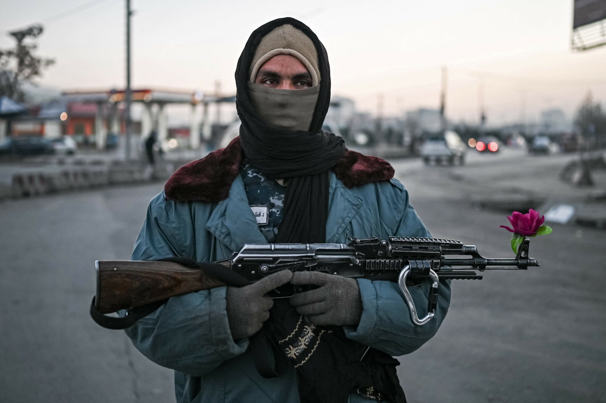 TOPSHOT - A Taliban fighter stands guard at a checkpoint on a street in Kabul on December 17, 2021. (Photo by Mohd RASFAN / AFP)