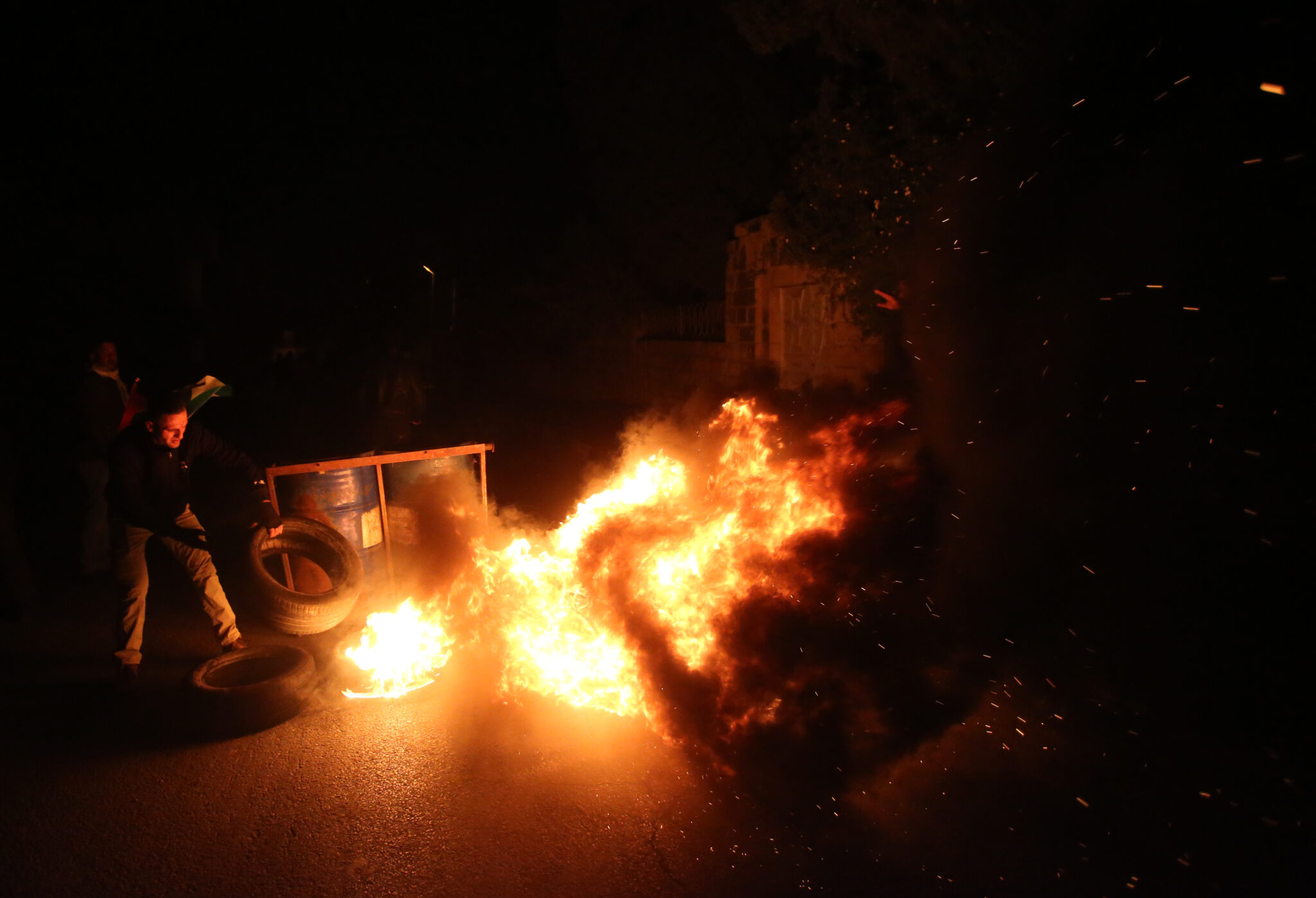 (220113) -- NABLUS, Jan. 13, 2022 (Xinhua) -- A Palestinian protester burns a tire during clashes with Israeli soldiers in the village of Burqa near the West Bank city of Nablus, on Jan. 13, 2022. (Photo by Ayman Nobani/Xinhua)