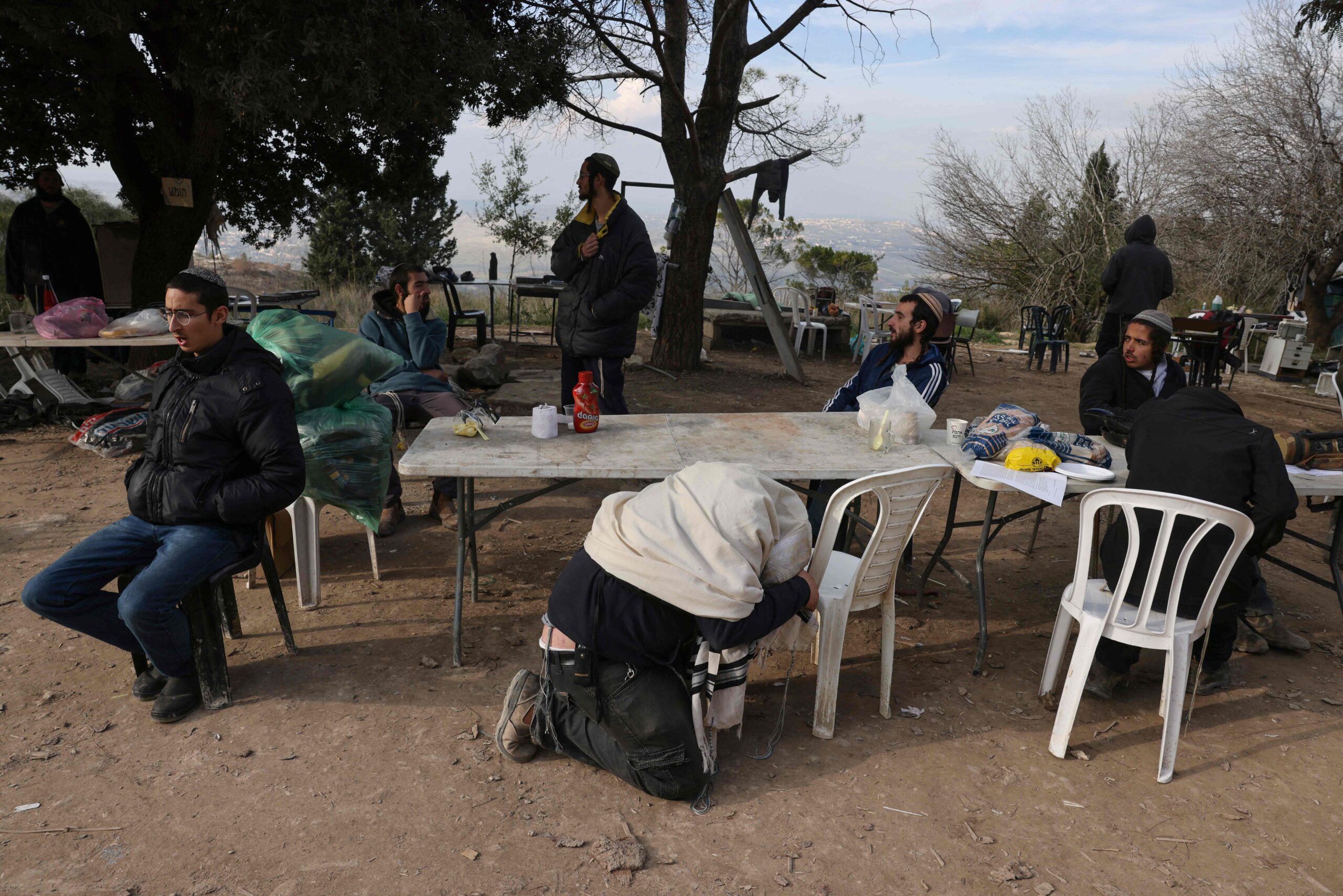 Israeli settlers, students at the Homesh Yeshiva (religious school), pray in the former settlement of Homesh west of the West Bank city of Nablus, on December 30, 2021. The Homesh settlement was demolished in 2005 as part of the Israeli disengagement from Gaza, along with a few other settlements in the north of the West Bank. (Photo by MENAHEM KAHANA / AFP)