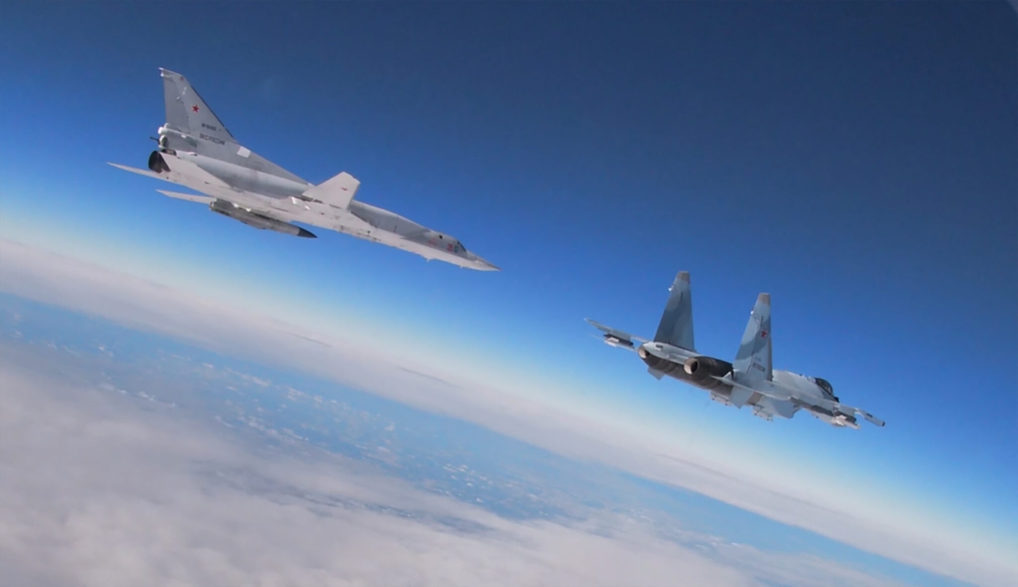 This handout video grab released by the Russian Defence Ministry on February 9, 2022 shows a Tupolev Tu-22M3 Backfire strategic bomber (L) and a Su-35 multirole supermaneuverable fighter flying during joint exercises of the armed forces of Russia and Belarus as part of an inspection of the Union State's Response Force. Russia and Belarus launched joint military drills despite concerns in Western countries that Moscow is plotting a major escalation of the conflict in Ukraine. The exercises, scheduled to continue until February 20 in Belarus, had begun and would centre around "suppressing and repelling external aggression," Russia's defence ministry said in a statement. - RESTRICTED TO EDITORIAL USE - MANDATORY CREDIT "AFP PHOTO /Russian Defence Ministry " - NO MARKETING - NO ADVERTISING CAMPAIGNS - DISTRIBUTED AS A SERVICE TO CLIENTS (Photo by Handout / RUSSIAN DEFENCE MINISTRY / AFP) / RESTRICTED TO EDITORIAL USE - MANDATORY CREDIT "AFP PHOTO /Russian Defence Ministry " - NO MARKETING - NO ADVERTISING CAMPAIGNS - DISTRIBUTED AS A SERVICE TO CLIENTS