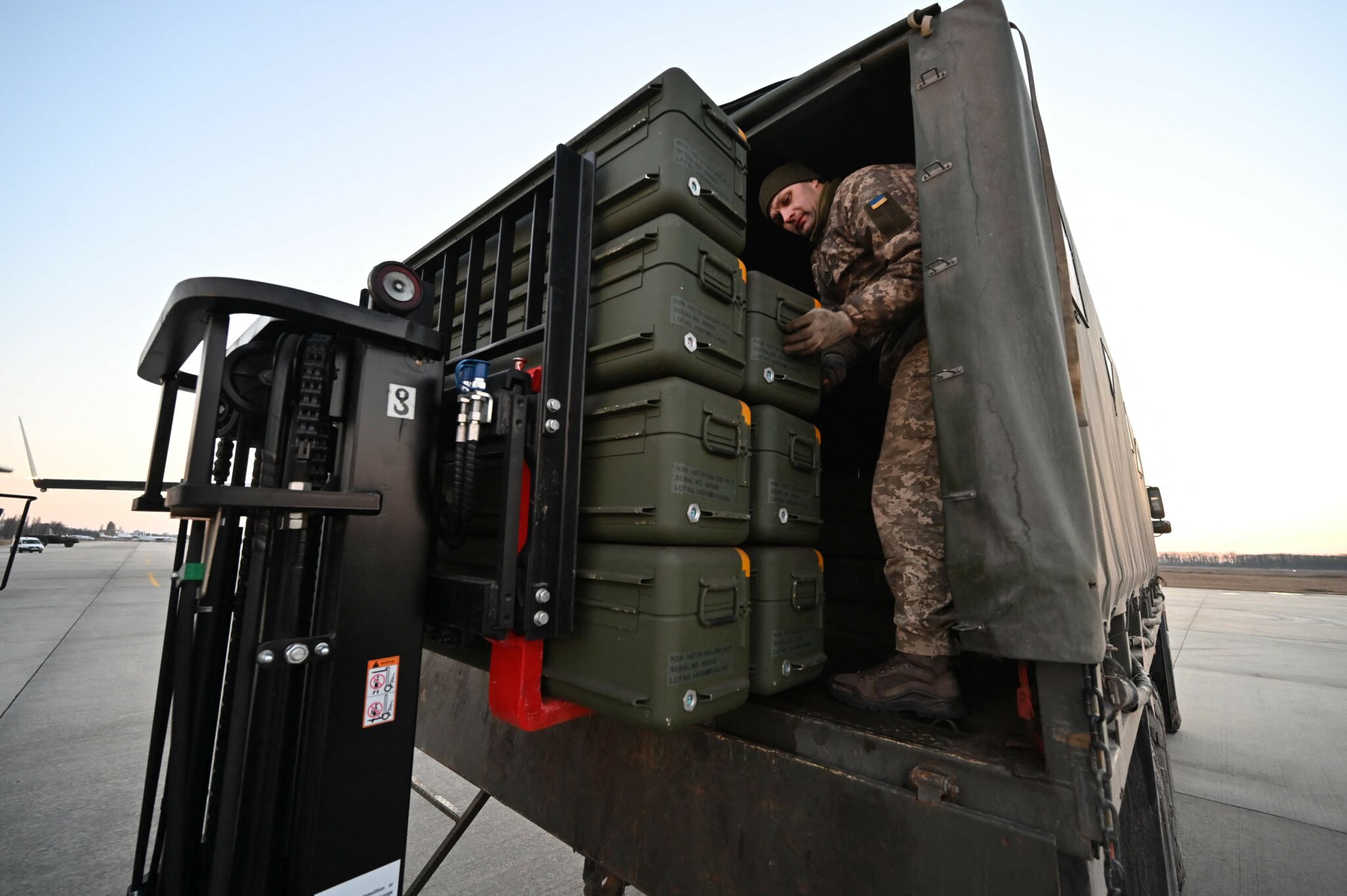 Servicemen of Ukrainian Military Forces move US made FIM-92 Stinger missiles, a man-portable air-defense system (MANPADS), that operates as an infrared homing surface-to-air missile (SAM), and the other military assistance shipped from Lithuania to Boryspil Airport in Kyiv on February 13, 2022. Ukrainian leader Volodymyr Zelensky will speak to US President Joe Biden "in the coming hours", his office said on February 13, 2022, as Western fears grow that Russia is about to invade the ex-Soviet state. The talks come one day after the White House reported there had been no breakthrough during a one-hour phone conversation between Biden and Russian President Vladimir Putin. (Photo by Sergei SUPINSKY / AFP)