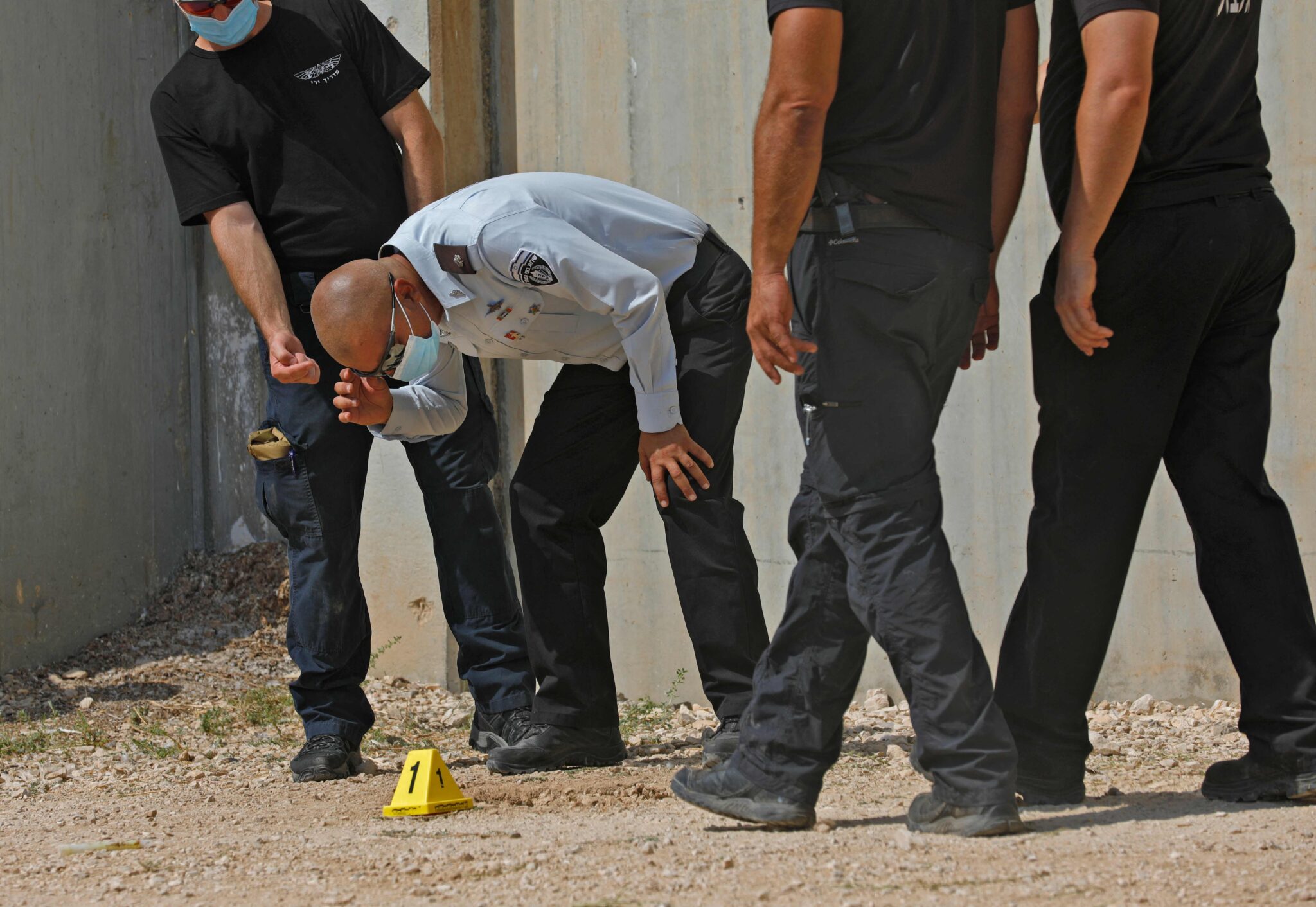 Head of Israel Prison Service Arik Yaakov (C) looks at an evidence outside the Gilboa Prison in northern Israel on September 6, 2021. Six Palestinians escaped from a prison in northern Israel through a tunnel dug beneath a sink, triggering a massive manhunt for the group that includes a prominent ex-militant, officials said. (Photo by JALAA MAREY / AFP)