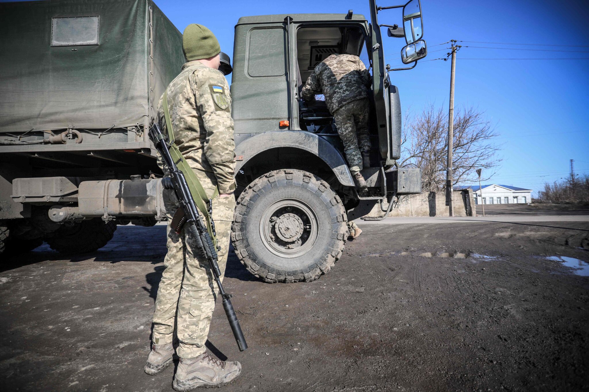 A Ukrainian Military Forces serviceman stands by a military vehicle in the Donetsk region town of Avdiivka, on the eastern Ukraine front-line with Russia-backed separatists on February 21, 2022. The rebel leaders of east Ukraine's two self-proclaimed republics asked Russian President to recognise the independence of their breakaway territories in a coordinated appeal on February 21. (Photo by Aleksey Filippov / AFP)