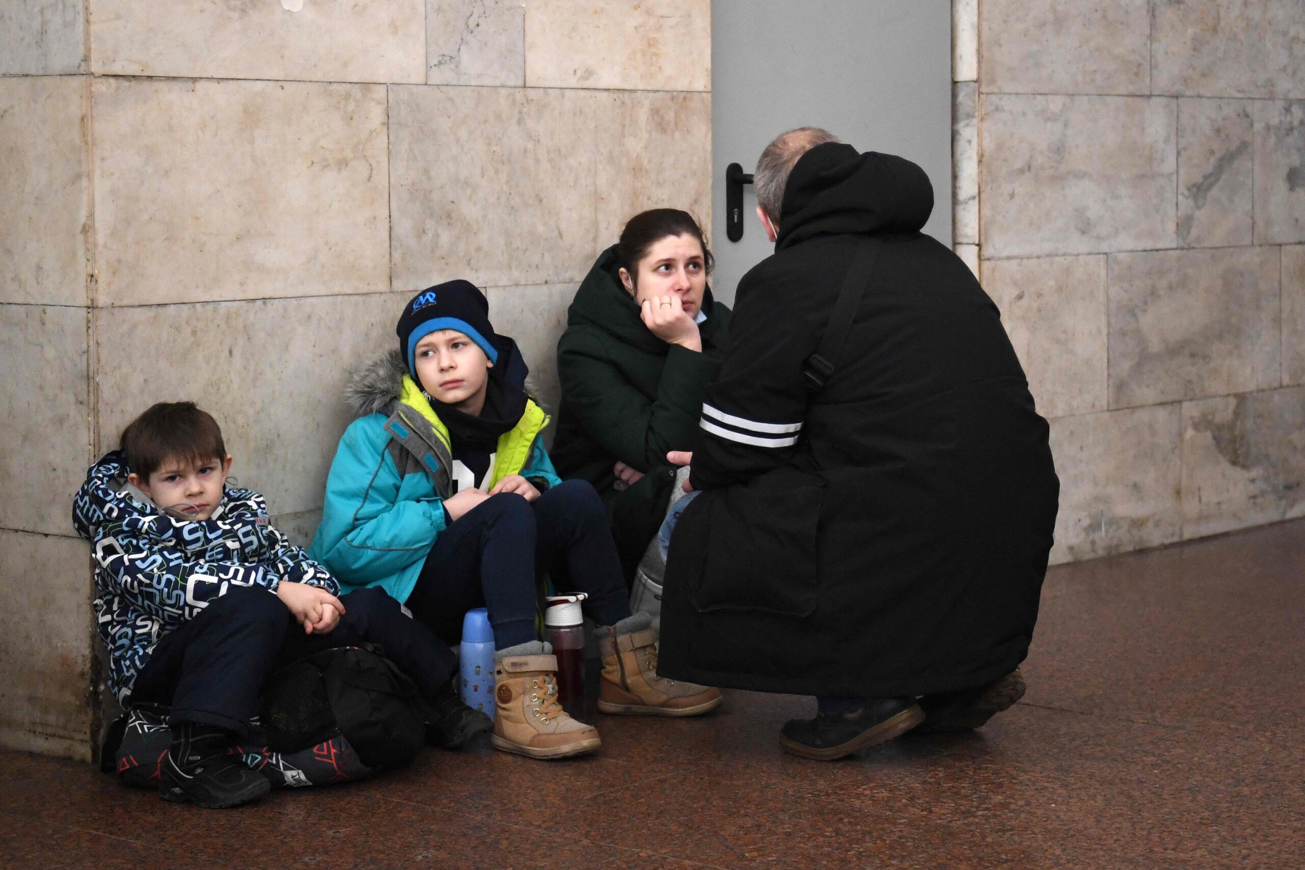 A family takes shelter in a metro station in Kyiv in the morning of February 24, 2022. Air raid sirens rang out in downtown Kyiv today as cities across Ukraine were hit with what Ukrainian officials said were Russian missile strikes and artillery. Russian President Vladimir Putin announced a military operation in Ukraine on Thursday with explosions heard soon after across the country and its foreign minister warning a "full-scale invasion" was underway. (Photo by Daniel LEAL / AFP)