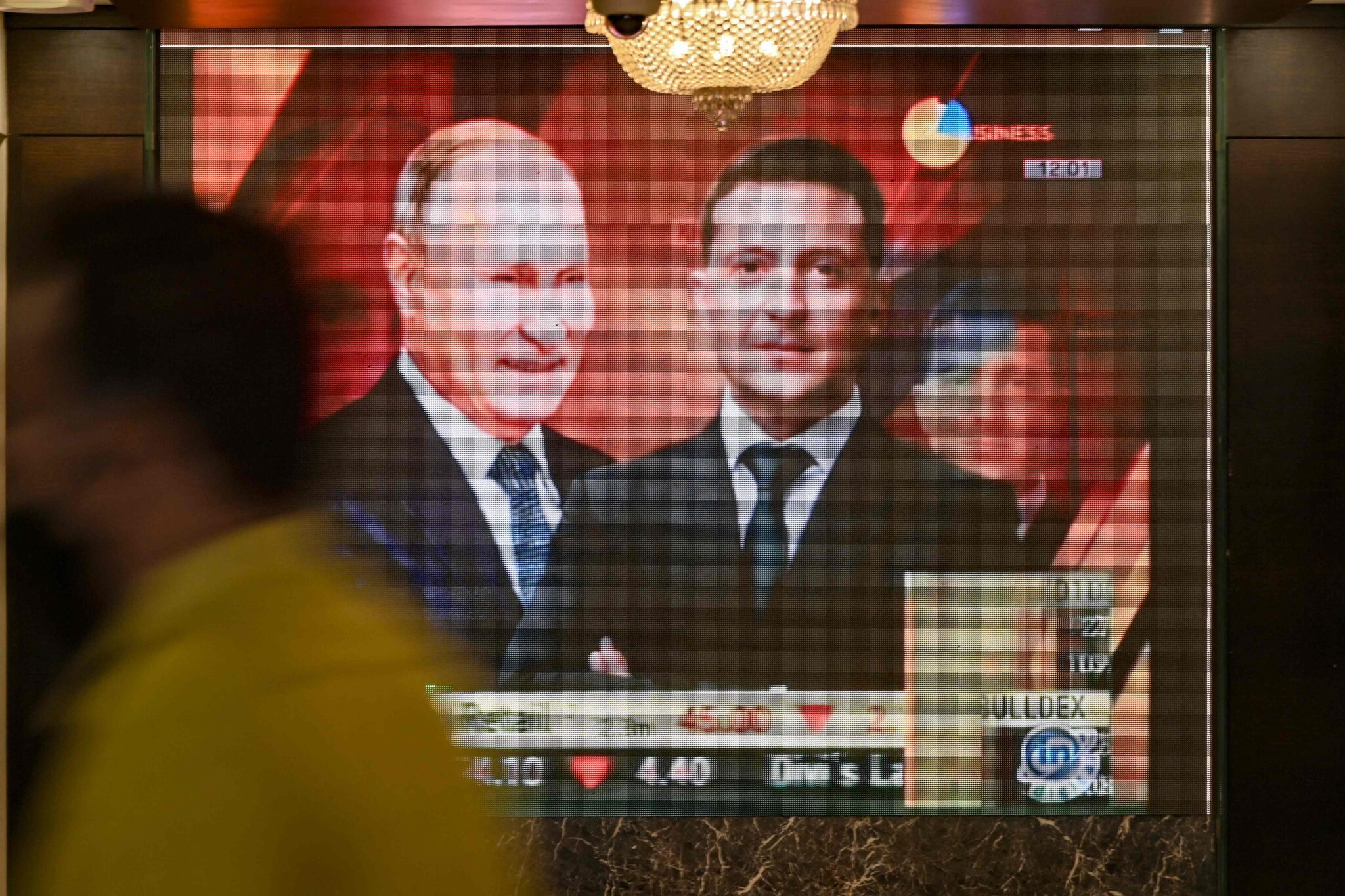 A man walks past a digital broadcast screen airing news of the conflict between Russia and Ukraine at the Bombay Stock Exchange (BSE) in Mumbai on February 24, 2022. (Photo by Indranil MUKHERJEE / AFP)